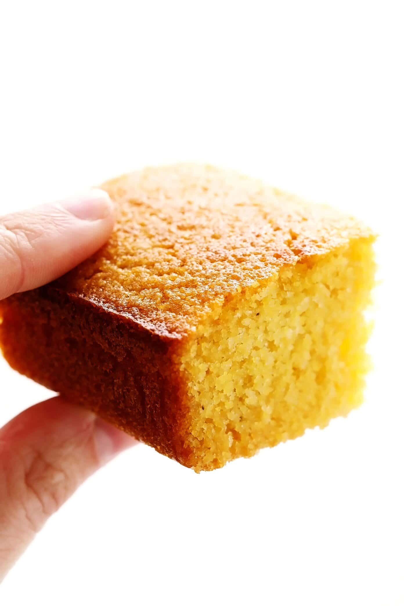 This amazing homemade cornbread recipe is lightly sweetened with honey, made extra moist with buttermilk, and tastes so buttery and delicious! Easy to make in a basic baking dish or cast iron skillet, or you can use this batter to make cornbread muffins. And perfect for serving with soup, chili, dressing/stuffing, or whatever sounds good! | gimmesomeoven.com #cornbread #bread #healthy #skillet #side #homemade #vegetarian #glutenfree Buttermilk Cornbread Closeup