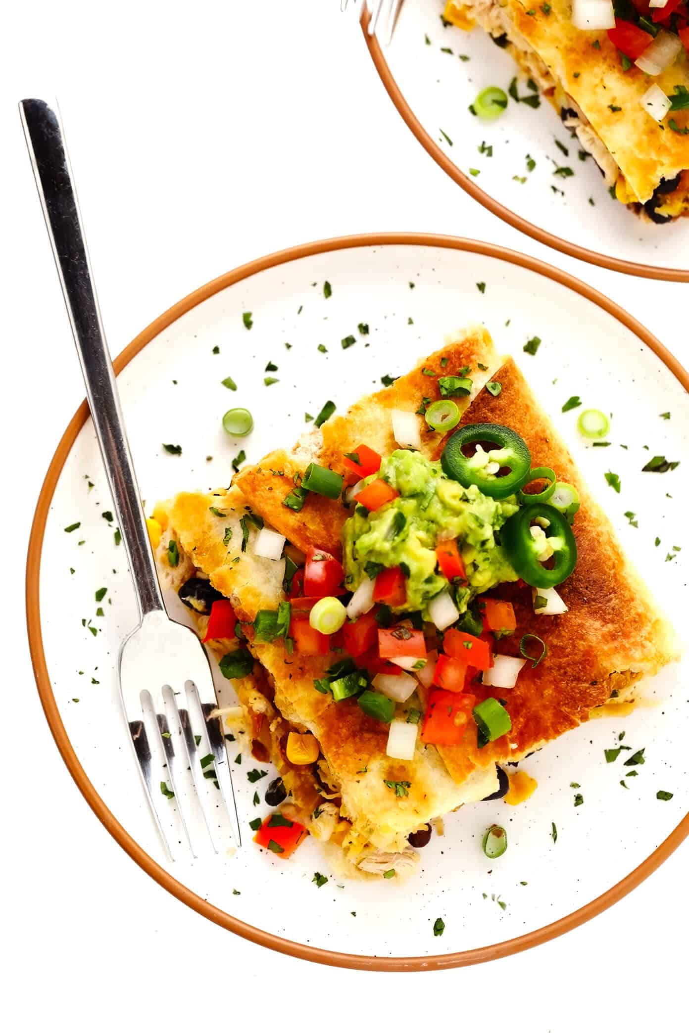 This party-sized chicken sheet pan quesadilla recipe is filled with a zesty mix of cheese, beans, veggies and baked up in a large sheet pan to feed a crowd. Serve as an appetizer, dinner entrée or game day snack with guacamole, salsa, sour cream or any of your favorite dips and enjoy! | gimmesomeoven.com #chicken #quesadilla #mexican #gameday #dinner #party #appetizer #cheese Individual Chicken Sheet Pan Quesadilla Serving with Guacamole and Pico de Gallo