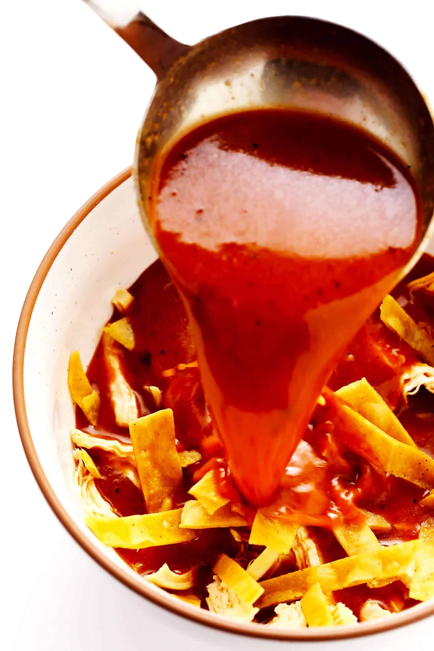 Pouring hot broth over tortilla strips to make authentic tortilla soup