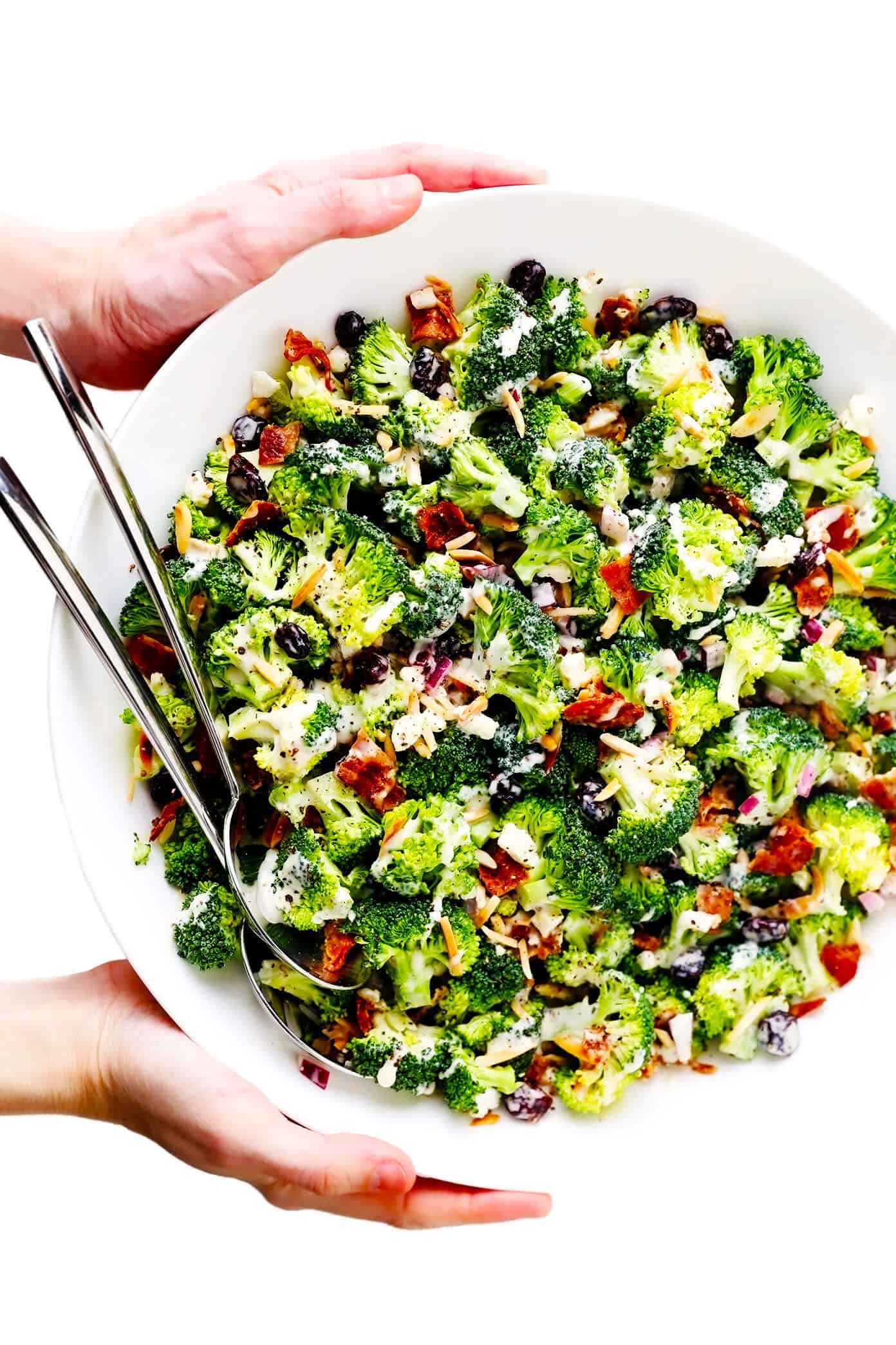 This classic broccoli salad recipe is made with fresh broccoli florets, crispy bacon, dried cranberries, toasted almonds, red onion, feta cheese, and a lightened-up creamy dressing. It's the perfect make-ahead side dish for picnics and potlucks and is always a crowd fave! | gimmesomeoven.com Bowl of Broccoli Salad with Bacon