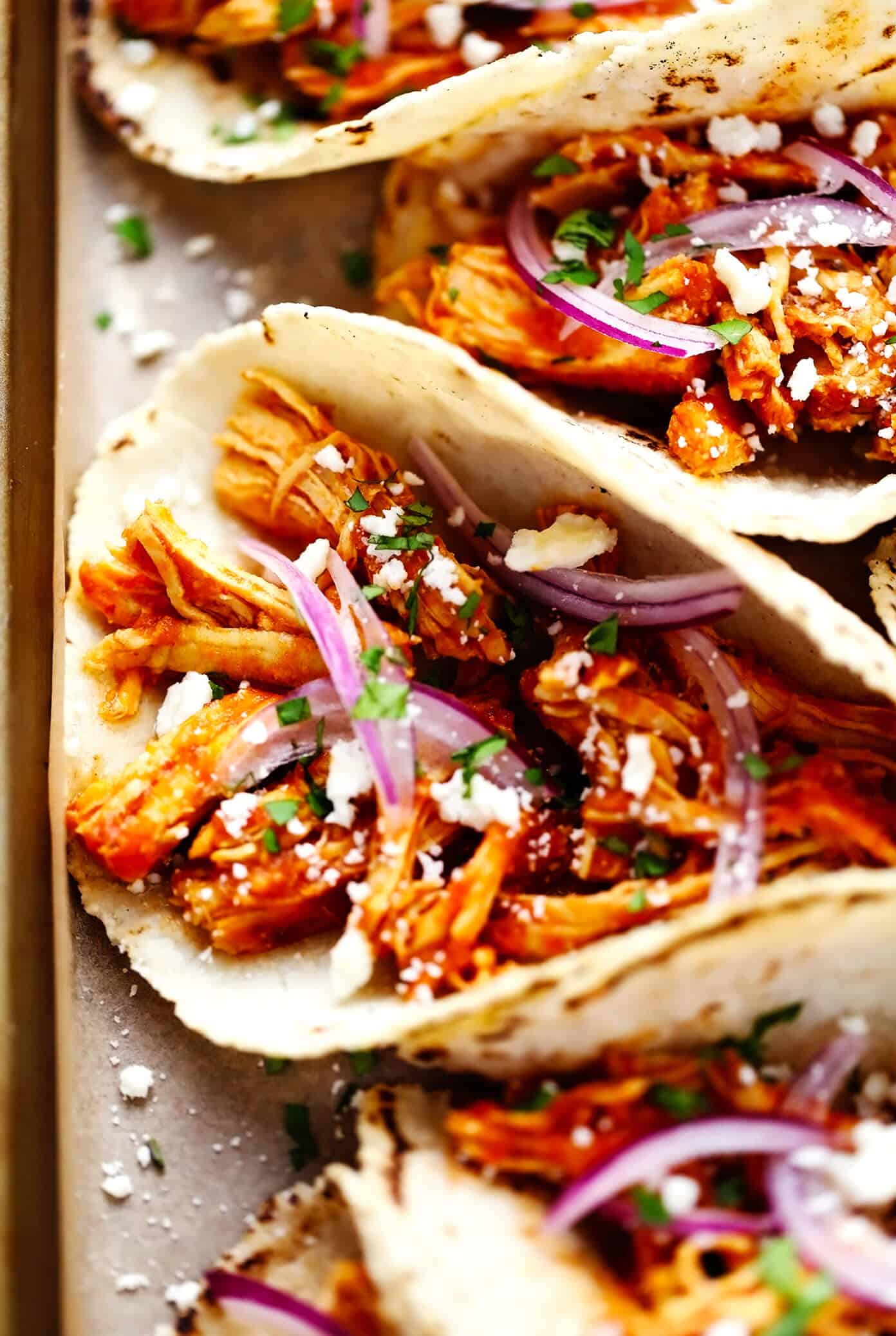 These Chicken Tinga Tacos are made with smoky chipotle chicken, served on warm corn tortillas, and loaded up with your favorite fresh toppings (such as avocado, cilantro, pickled red onions, cheese and more). Feel free to add refried beans or guacamole too, if you'd like. Always a delicious Mexican dinner recipe, and one that's ready to go in just over 30 minutes! | gimmesomeoven.com Chicken Tinga Tacos Closeup