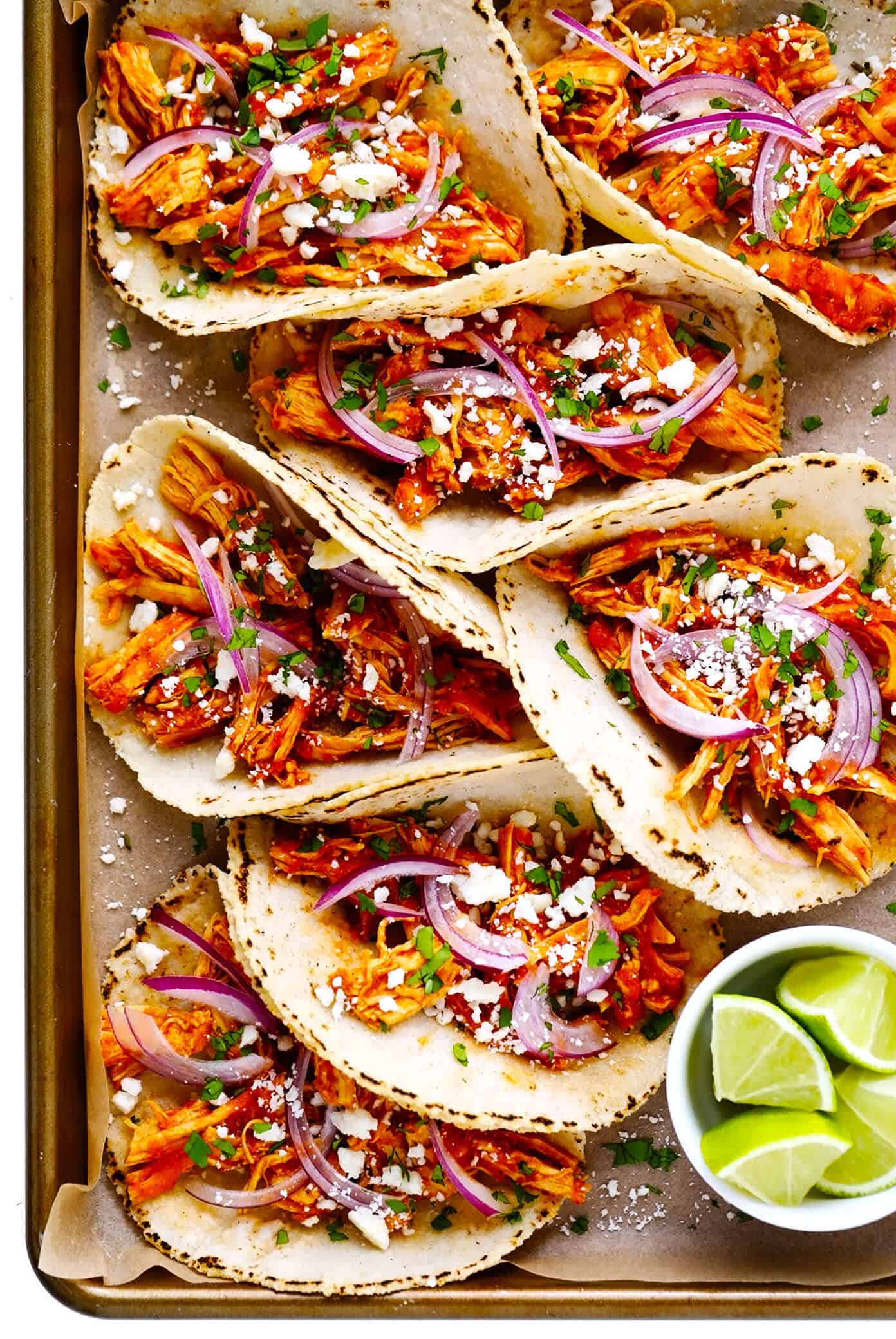 These Chicken Tinga Tacos are made with smoky chipotle chicken, served on warm corn tortillas, and loaded up with your favorite fresh toppings (such as avocado, cilantro, pickled red onions, cheese and more). Feel free to add refried beans or guacamole too, if you'd like. Always a delicious Mexican dinner recipe, and one that's ready to go in just over 30 minutes! | gimmesomeoven.com Chicken Tinga Tacos Recipe