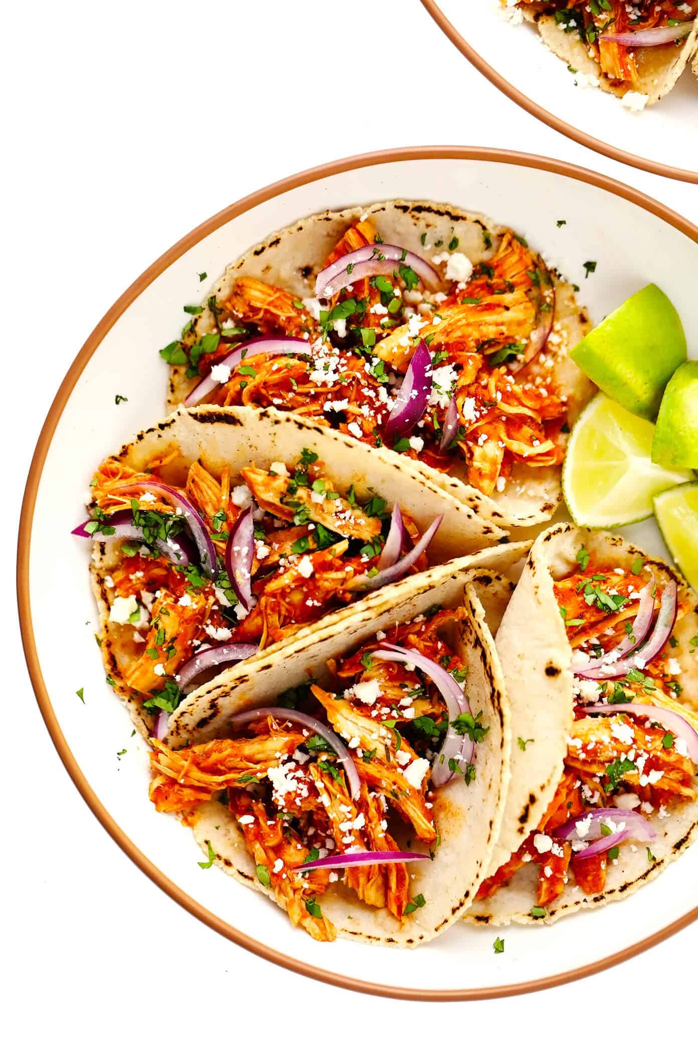 These Chicken Tinga Tacos are made with smoky chipotle chicken, served on warm corn tortillas, and loaded up with your favorite fresh toppings (such as avocado, cilantro, pickled red onions, cheese and more). Feel free to add refried beans or guacamole too, if you'd like. Always a delicious Mexican dinner recipe, and one that's ready to go in just over 30 minutes! | gimmesomeoven.com Chicken Tinga Tacos in Bowls with Limes