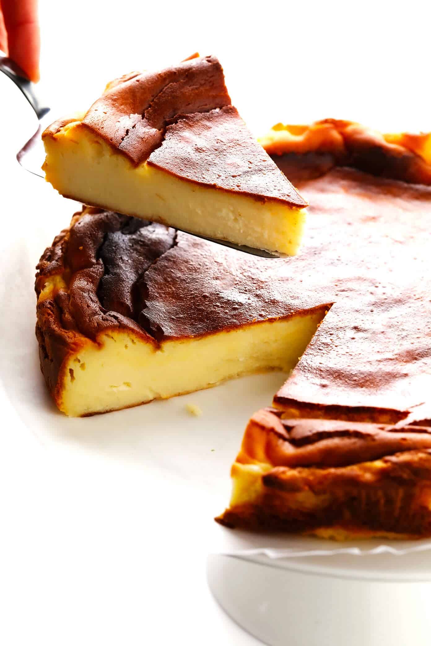 This "Burnt" Basque Cheesecake recipe (known here in Spain as 'tarta de queso') is uniquely light, creamy, delicious, caramelized, and so easy to make that it's nearly foolproof! Such a great dessert recipe for all occasions. | gimmesomeoven.com #basque #cheesecake #spanish #spain #sansebastian #dessert #tartadequeso #caramelized Serving slices of Basque Cheesecake (Tarta de Queso La Viña)