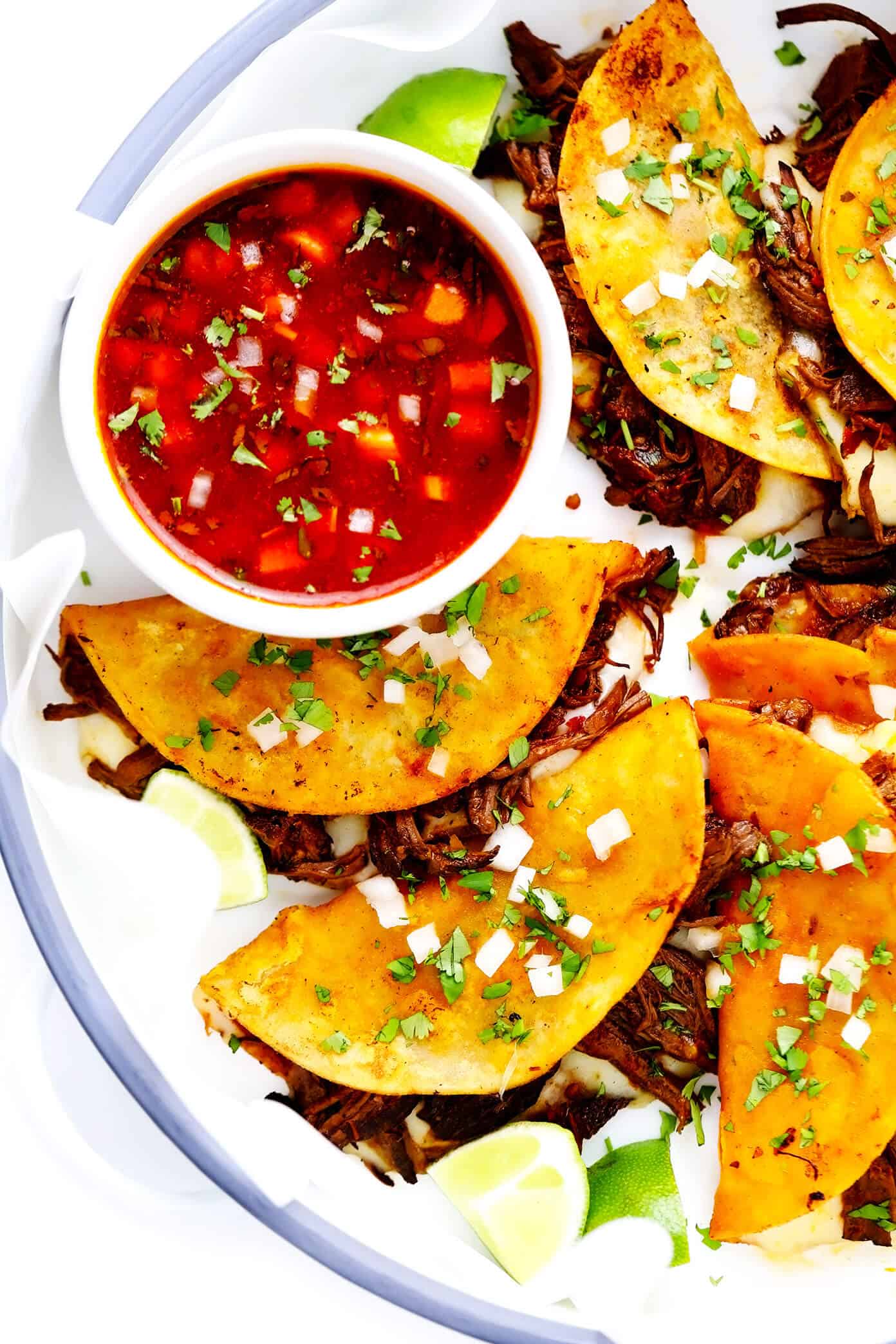This birria tacos recipe (a.k.a. birria quesatacos) is made with tender birria beef, which is loaded into broth-dipped corn tortillas with cheese, fried until crispy, then dunked in birria broth for an extra-flavorful finish. Easy to make in either the Instant Pot, Crock-Pot or on the stovetop, and always a delicious Mexican dinner recipe! | gimmesomeoven.com #beef #birria #tacos #quesatacos #cheese #dip #sauce #fried #tortillas #jalisco #mexican Birria Tacos with Dipping Sauce