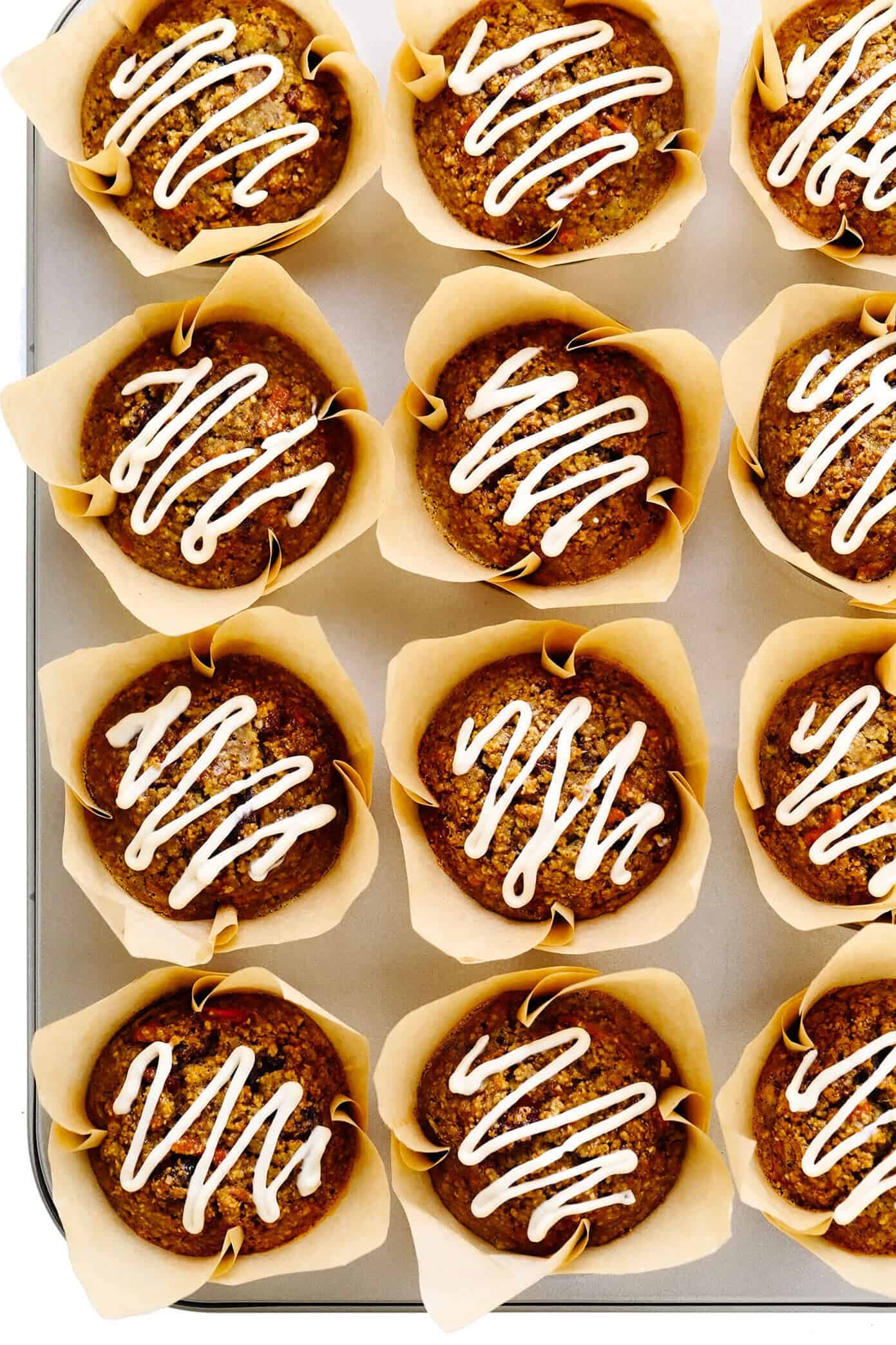 These Healthy Carrot Cake Muffins are easy to make with oatmeal, lots of fresh carrots, maple syrup, and a handful of other simple and healthy ingredients. Feel free to top them with a lightened-up cream cheese frosting drizzle, and add in raisins, nuts and/or coconut if you'd like too. Perfect for a feel-good breakfast, snack or dessert! | gimmesomeoven.com #carrot #cake #muffins #healthy #creamcheese #frosting #icing #breakfast #snack #vegetarian #glutenfree #easter #spring Healthy Carrot Cake Muffins with Cream Cheese Drizzle