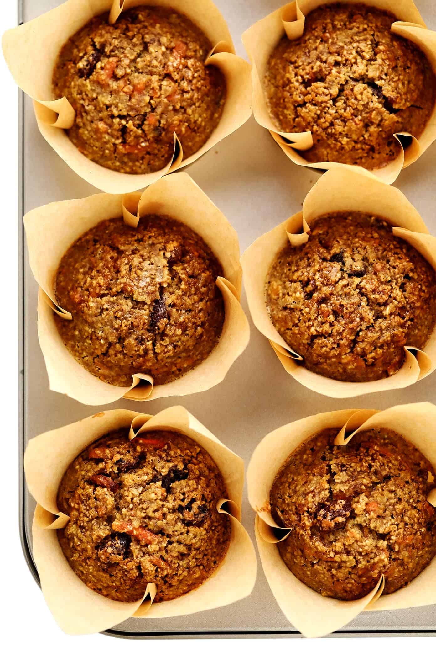 These Healthy Carrot Cake Muffins are easy to make with oatmeal, lots of fresh carrots, maple syrup, and a handful of other simple and healthy ingredients. Feel free to top them with a lightened-up cream cheese frosting drizzle, and add in raisins, nuts and/or coconut if you'd like too. Perfect for a feel-good breakfast, snack or dessert! | gimmesomeoven.com #carrot #cake #muffins #healthy #creamcheese #frosting #icing #breakfast #snack #vegetarian #glutenfree #easter #spring Healthy Carrot Muffins in Pan