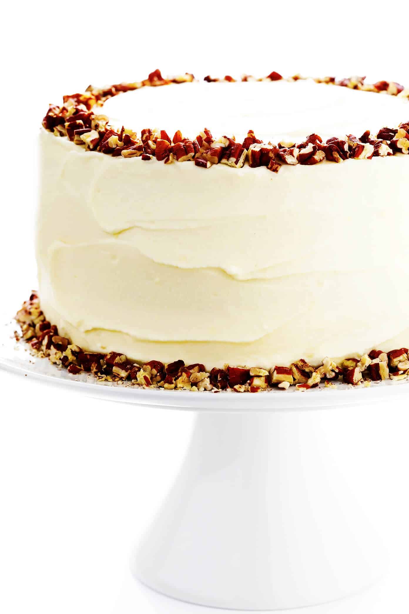 This delicious hummingbird cake recipe features ultra-moist pineapple banana cake layered with rich cream cheese frosting and a sprinkle of toasted pecans. It's the perfect dessert for spring, summer, or Easter and it's always a crowd fave! | gimmesomeoven.com #cake #dessert #hummingbird #jamaican #southern #creamcheese #frosting #icing #banana #pineapple #pecan Doctor Bird Cake (Hummingbird Cake) on Pedestal