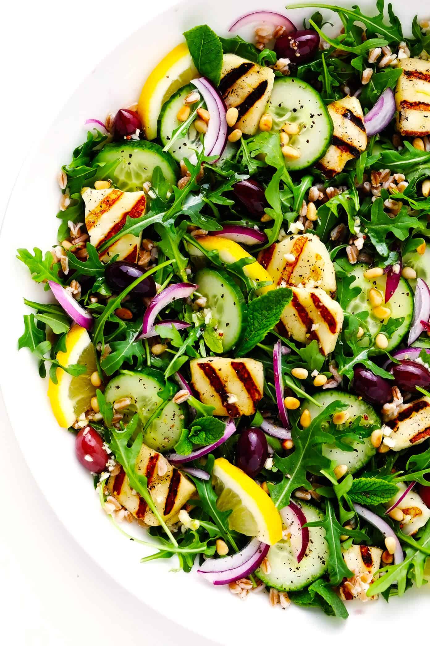 This Mediterranean-inspired grilled halloumi salad is easy to make with pan-grilled halloumi cheese, chewy farro, fresh cucumber and mint, and a zippy lemon dressing. It's the perfect side or entree salad to serve for dinner. And feel free to add in chicken, beef, shrimp or chickpeas if you'd like, too! | gimmesomeoven.com Grilled Halloumi Salad in Bowl