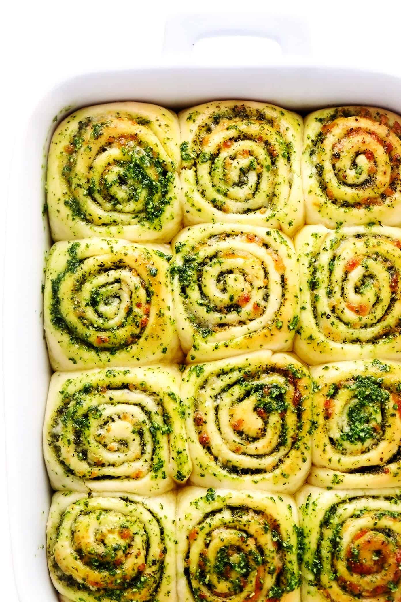 These deliciously cheesy pesto rolls are made with a buttery soft bread dough and swirled with fresh basil pesto, mozzarella and Parmesan cheese. Easy to make in about 1 hour and sure to be a favorite side dish! | gimmesomeoven.com Cheesy Pesto Rolls