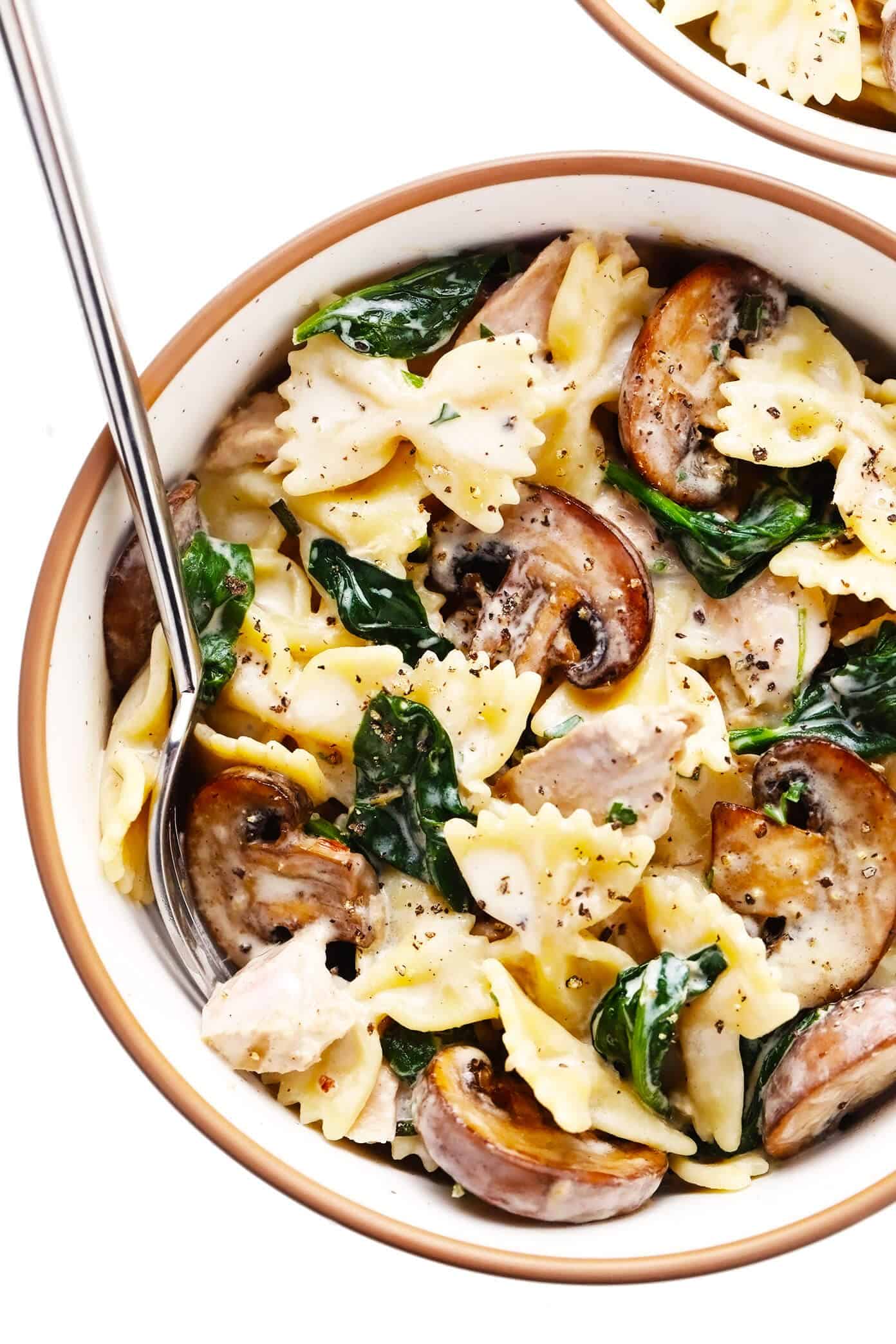 This creamy tuna mushroom pasta recipe is tossed with perfectly al dente pasta, sautéed mushrooms, tender spinach, canned tuna, and garlic lemon rosemary cream sauce. It's a super easy dinner recipe to make in just 30 minutes and taste SO delicious! | gimmesomeoven.com Creamy Tuna Mushroom Pasta in Serving Bowl
