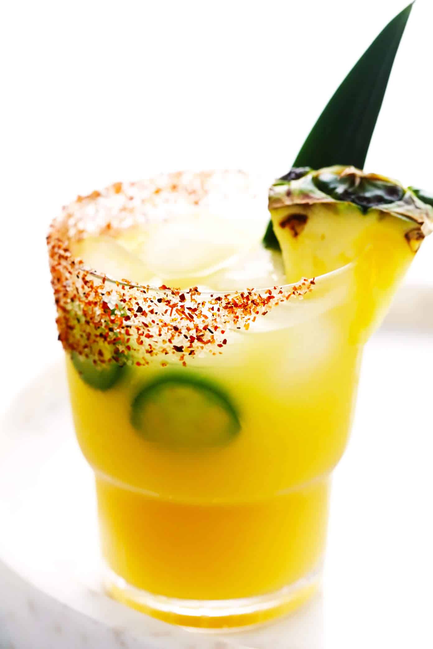 This spicy pineapple margarita recipe is super easy to make and perfectly balanced with sweet, sour, spicy, and smoky (if you opt for mezcal over tequila) flavors. Feel free to add however much or little jalapeño that you prefer to your cocktail! | gimmesomeoven.com Spicy Pineapple Margarita with Jalapeño in Glass