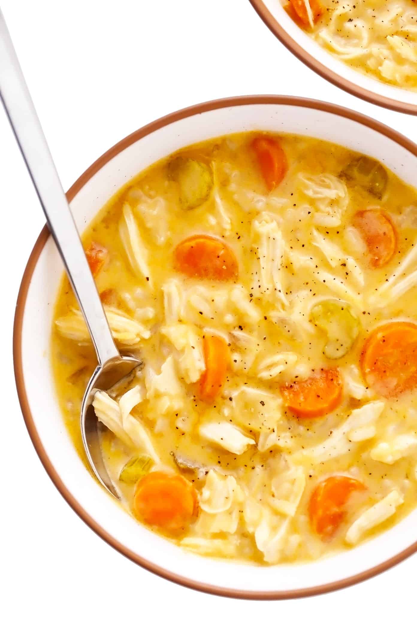 This creamy buffalo chicken and rice soup recipe is simmered with tender chicken, veggies, rice and a zesty blend of buffalo seasonings. Highly recommend topping with blue cheese and bacon too! Perfect for game day or easy weeknight dinner. Stovetop, Instant Pot and Crock-Pot options included. | gimmesomeoven.com Bowl of buffalo chicken and rice soup