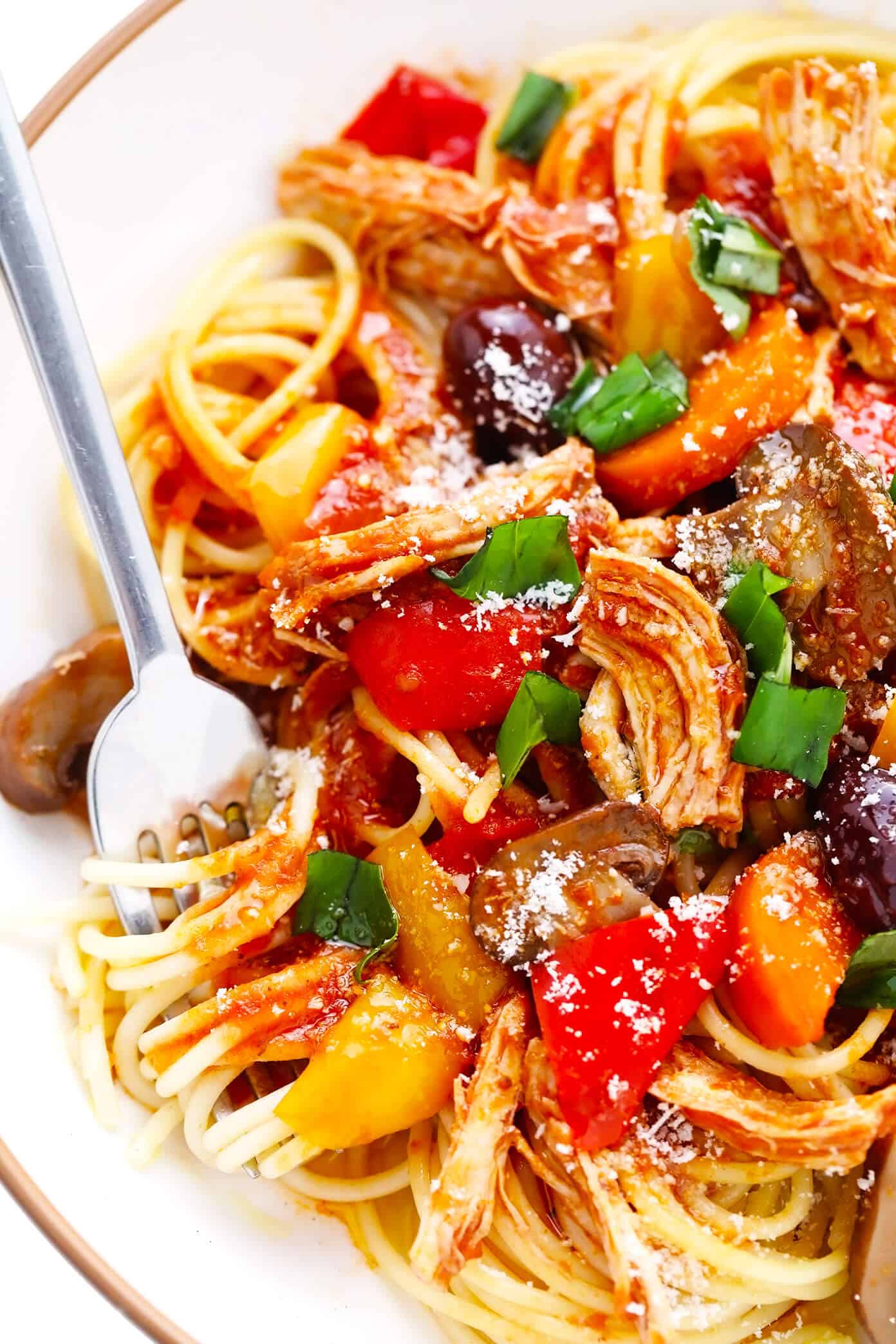 This chicken cacciatore recipe is easy to make with your choice of veggies and simmered in a flavorful garlic-herb tomato sauce. Easy to make in either the Instant Pot, Crock-Pot or on the stovetop and delicious served over pasta or polenta. Always a great dinner recipe for Italian night! | gimmesomeoven.com Bowl of Chicken Cacciatore with Spaghetti