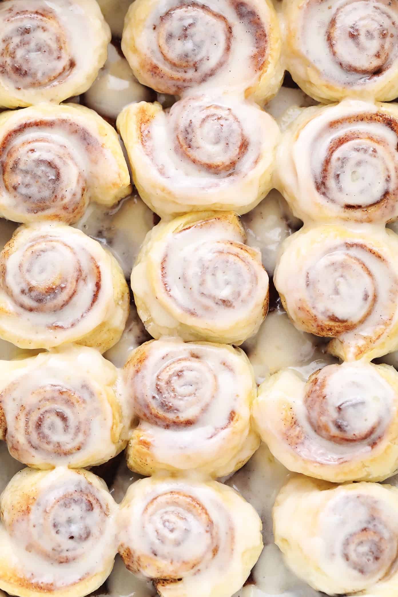 This shortcut puff pastry cinnamon rolls recipe is super fast and easy to prepare, topped with a dreamy cream cheese frosting, and irresistibly buttery, flaky and delicious. The perfect breakfast or brunch pastry when you need something quick! | gimmesomeoven.com Closeup of puff pastry cinnamon rolls