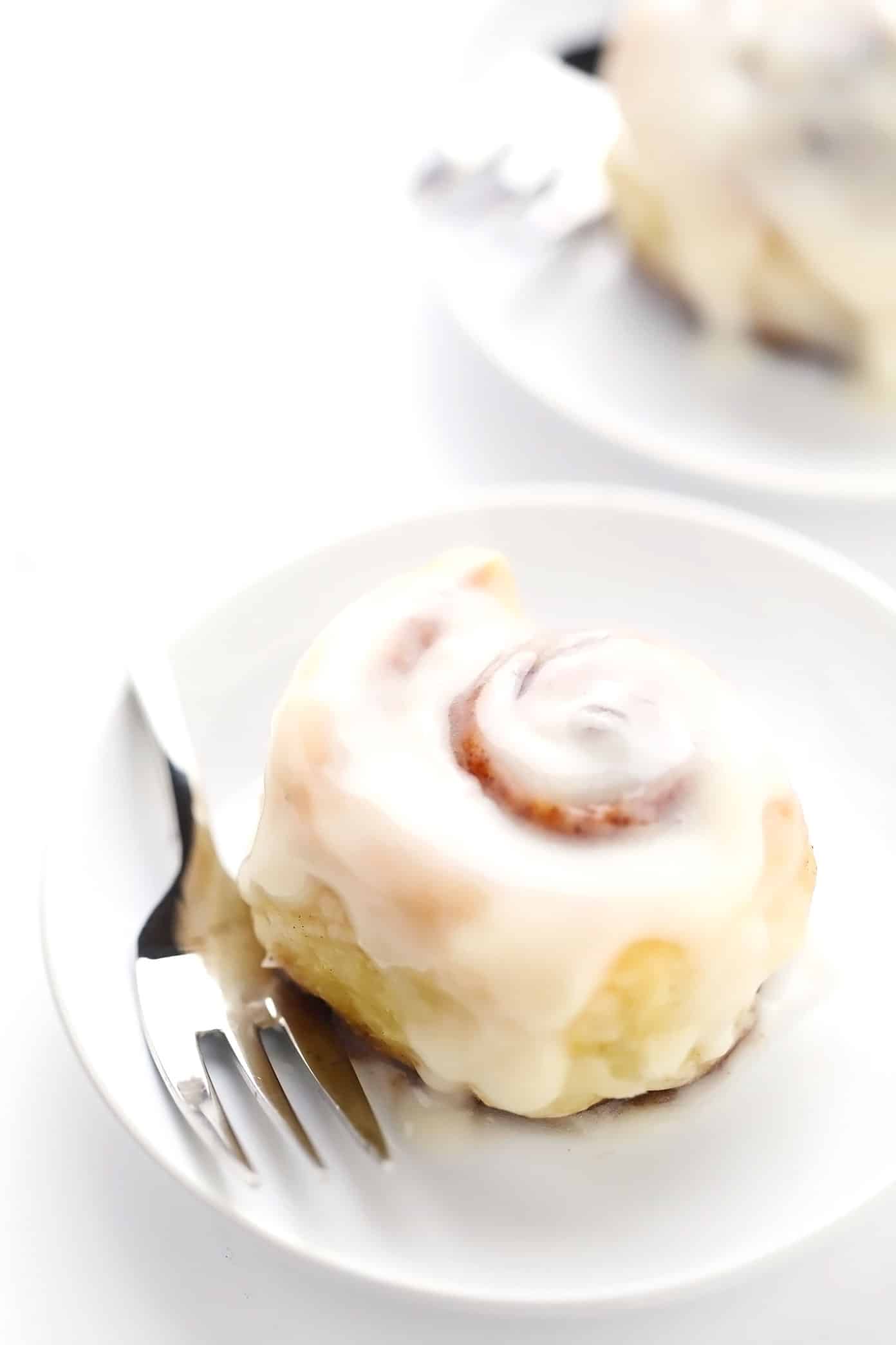 This shortcut puff pastry cinnamon rolls recipe is super fast and easy to prepare, topped with a dreamy cream cheese frosting, and irresistibly buttery, flaky and delicious. The perfect breakfast or brunch pastry when you need something quick! | gimmesomeoven.com Puff pastry cinnamon rolls on serving plates