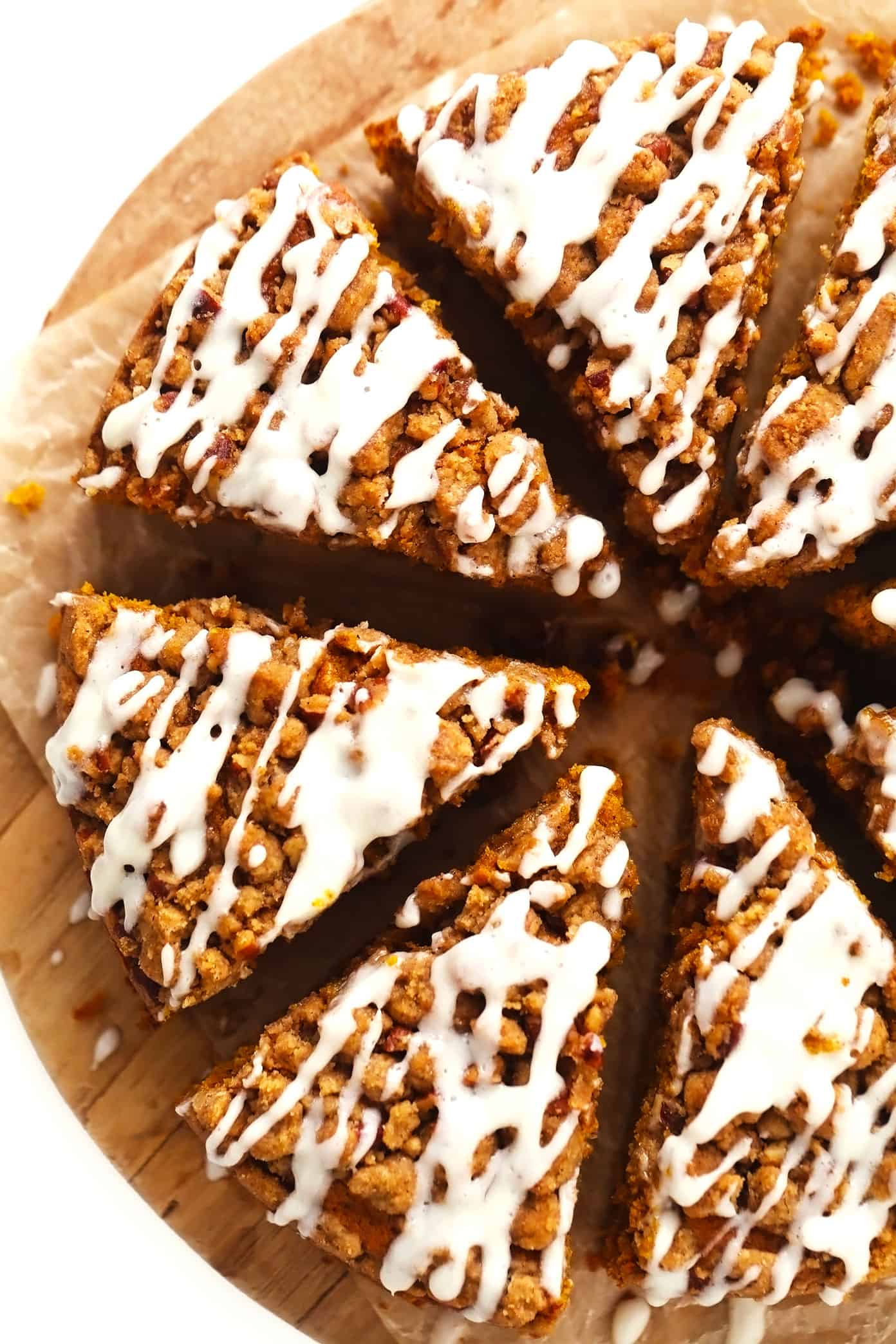 This pumpkin coffee cake is moist and perfectly spiced, then topped with a crunchy streusel crumb topping and a quick cream cheese drizzle. It's easy to make and the perfect breakfast or brunch treat for fall or the holidays! | gimmesomeoven.com Slices of pumpkin coffee cake with streusel and cream cheese drizzle