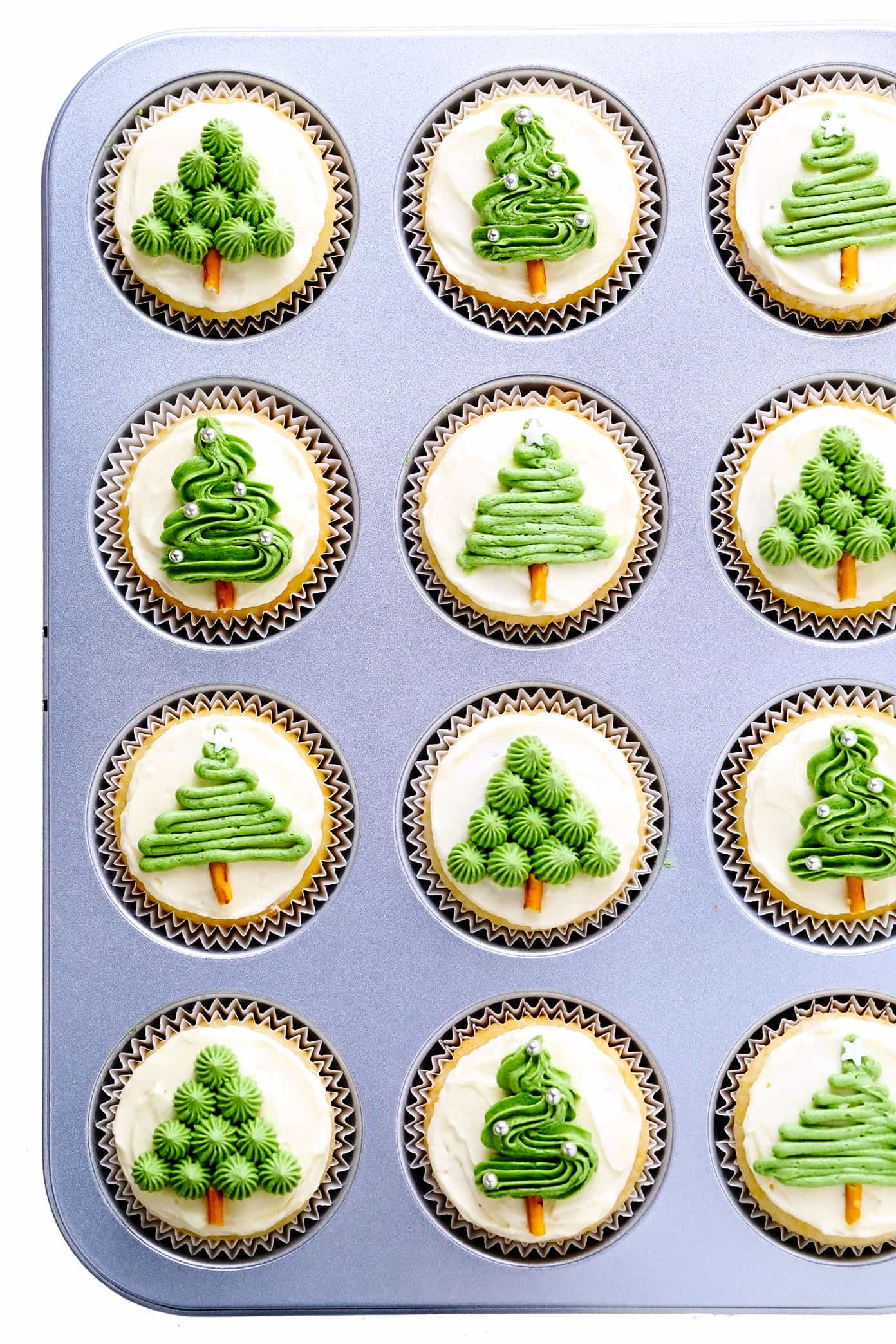 These cute Christmas cupcakes are made with soft and fluffy vanilla cupcakes, a simple vanilla buttercream frosting, and whatever fun sprinkles or toppings you choose. Decorating instructions and supply list included too for this fun holiday dessert! | gimmesomeoven.com Christmas Tree Cupcakes