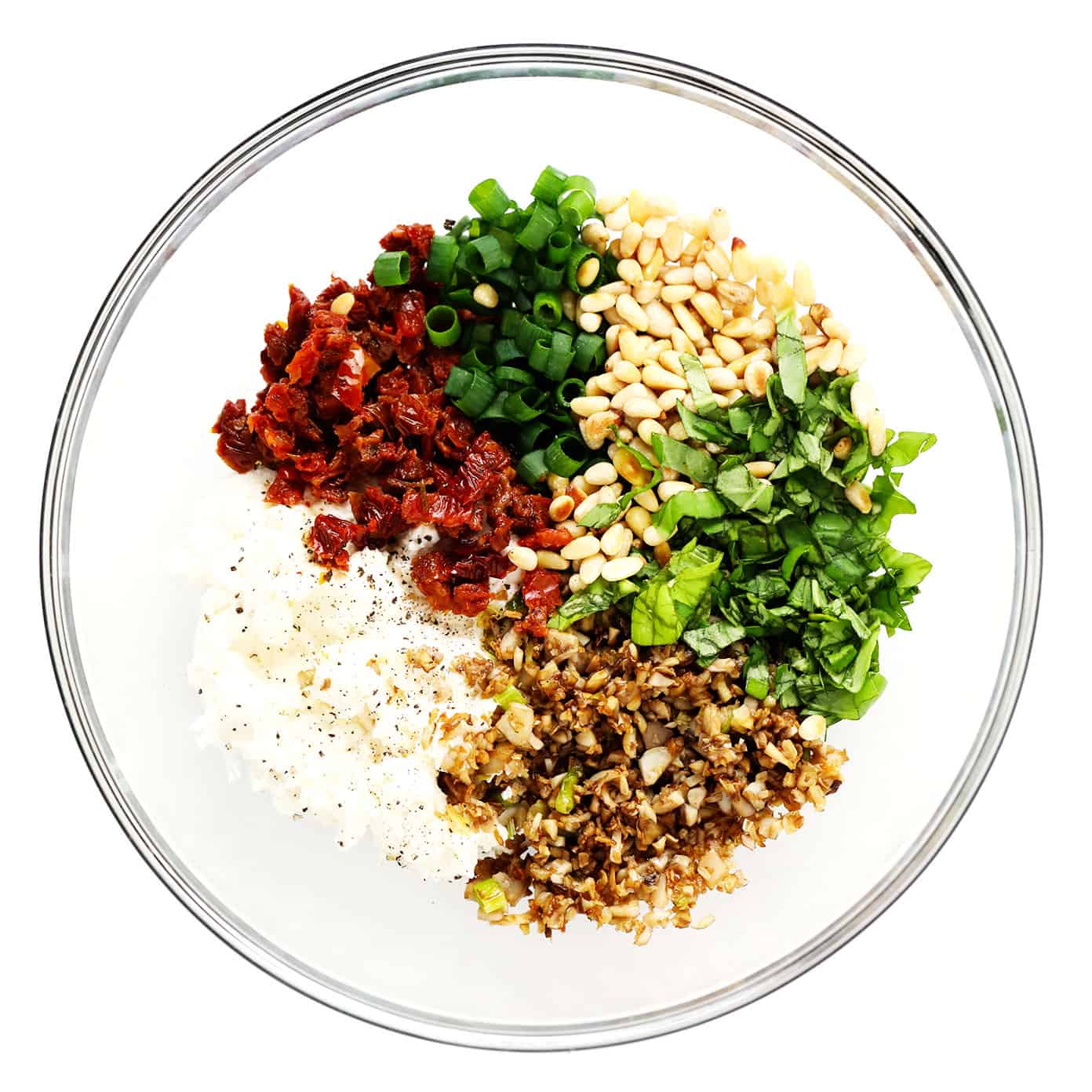 This easy stuffed mushrooms recipe is made with a garlicky goat cheese, sun-dried tomato, pine nut and basil filling and topped with crispy toasted breadcrumbs. The perfect vegetarian appetizer that's easy to make ahead of time (up to 1 day in advance) and always a crowd fave! | gimmesomeoven.com Stuffed Mushroom Ingredients in Bowl