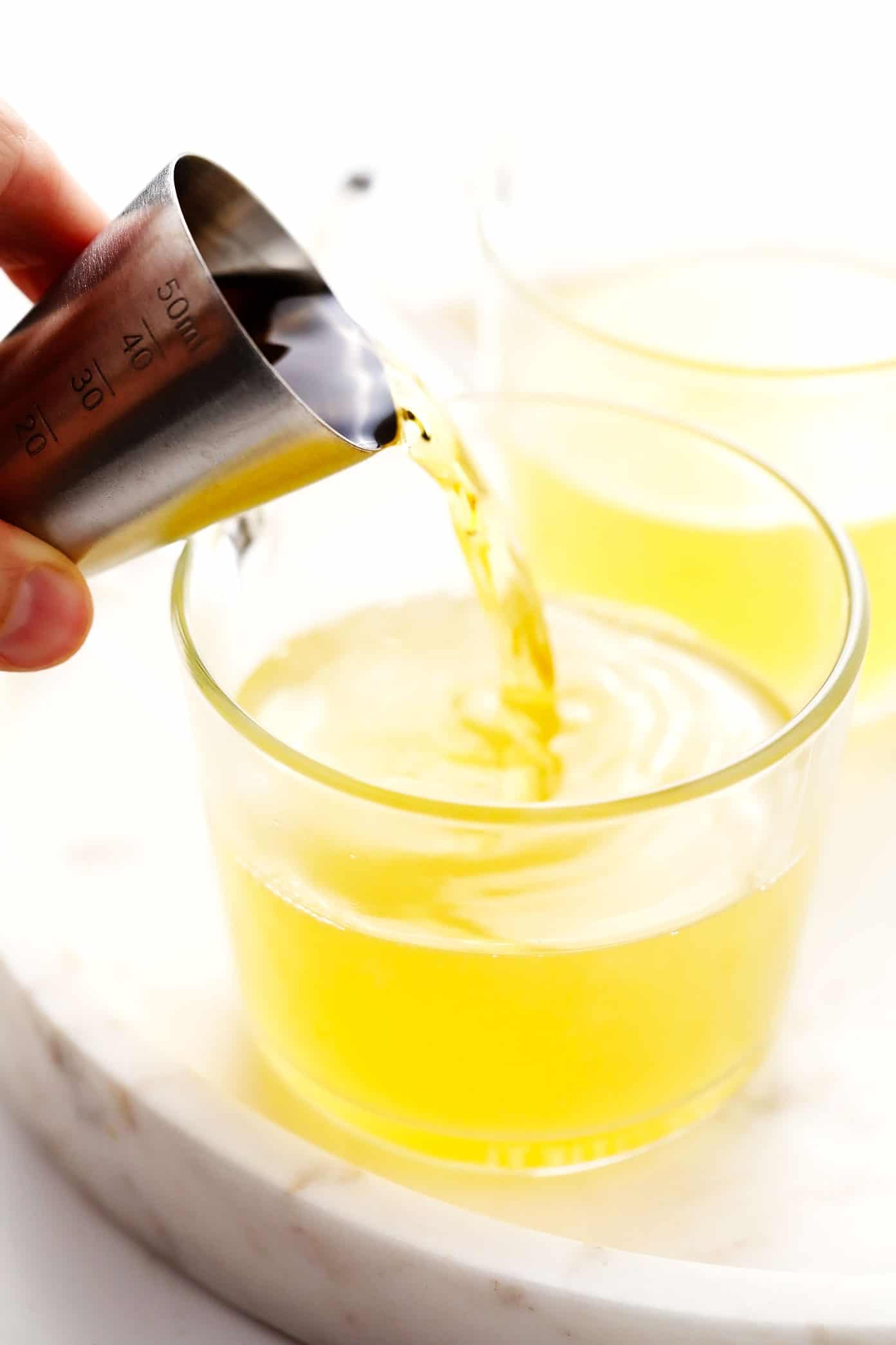 This classic hot toddy recipe is easy to make in just 5 minutes with hot water, whiskey, lemon and honey. Feel free to use your favorite type of whiskey for this cocktail, plus any additional add-ins (I recommend fresh ginger) or garnishes (such as cinnamon, star anise or citrus twists) that you enjoy. You can also omit the alcohol altogether to make this a non-alcoholic drink. | gimmesomeoven.com Demonstrating how to make a hot toddy