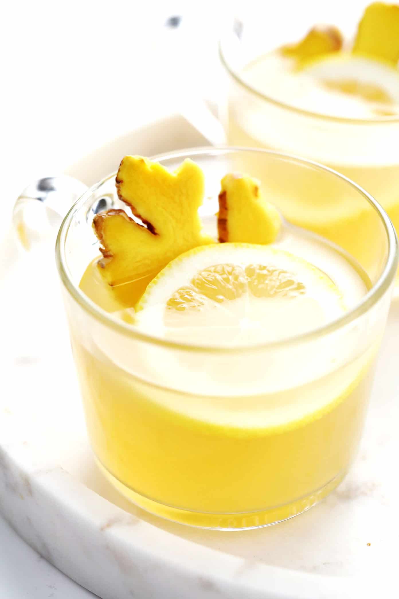 This classic hot toddy recipe is easy to make in just 5 minutes with hot water, whiskey, lemon and honey. Feel free to use your favorite type of whiskey for this cocktail, plus any additional add-ins (I recommend fresh ginger) or garnishes (such as cinnamon, star anise or citrus twists) that you enjoy. You can also omit the alcohol altogether to make this a non-alcoholic drink. | gimmesomeoven.com Hot Toddy with Ginger and Lemon Garnishes