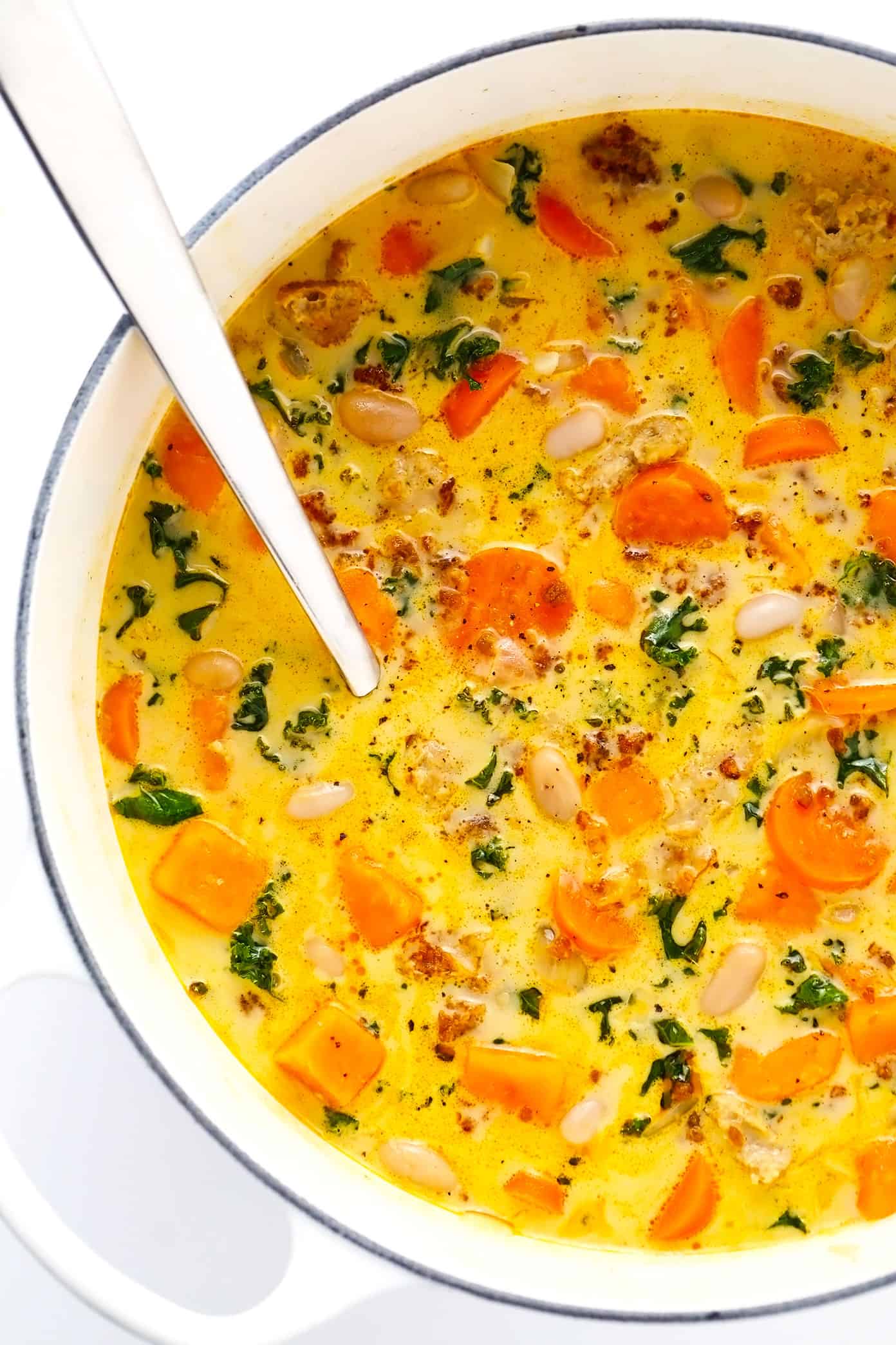 This Creamy Sweet Potato and Sausage Soup recipe is made with zesty sausage, seasonal veggies and kale, tender white beans, and a creamy, garlicky, paprika-sage broth. Easy to make vegan, if you use plant-based sausage, and naturally gluten-free. The perfect cozy dinner for fall and winter. | gimmesomeoven.com Creamy Sweet Potato and Sausage Soup in Stockpot
