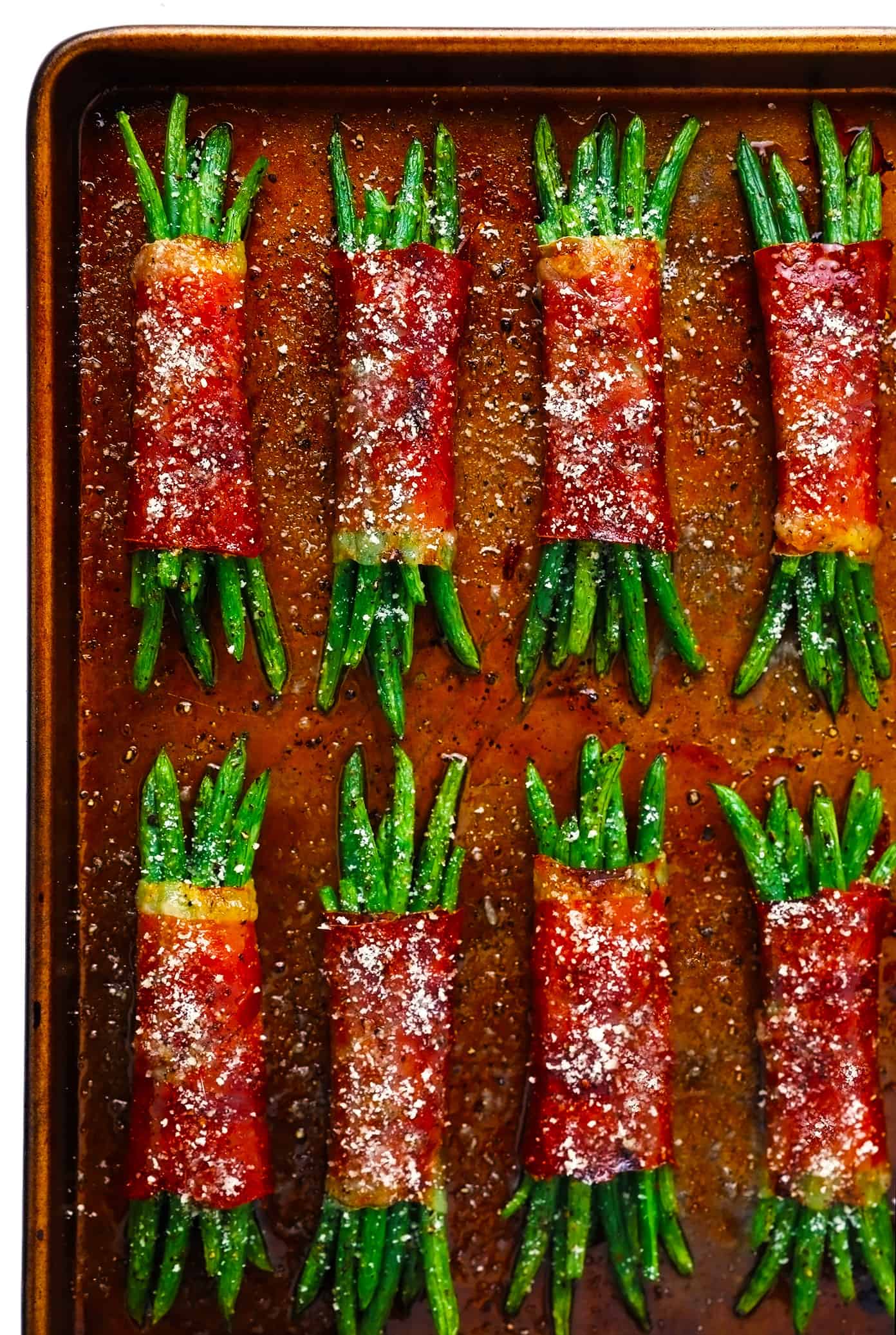These green bean bundles are tossed with rosemary honey garlic butter, wrapped in prosciutto, and sprinkled with freshly-grated Parmesan. Super easy to make ahead and only 10 minutes needed to bake. Perfect for your Thanksgiving, Christmas, or holiday menu...yet also easy enough for a fun weeknight side dish. | gimmesomeoven.com Prosciutto Wrapped Green Bean Bundles