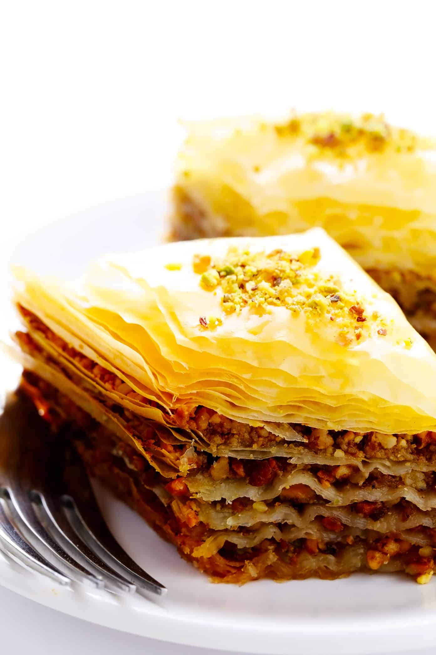 A step-by-step guide (and video) for how to make homemade baklava with perfectly crispy golden layers of buttery phyllo, pistachios and walnuts (or your choice of nuts), and lovely orange honey syrup. Always such a delicious treat! | gimmesomeoven.com Individual pieces of homemade baklava