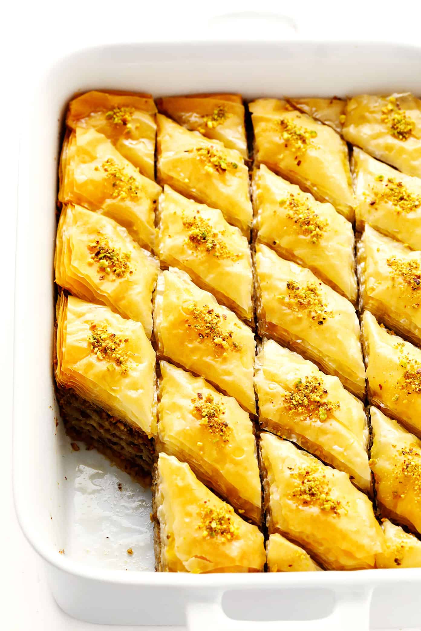 A step-by-step guide (and video) for how to make homemade baklava with perfectly crispy golden layers of buttery phyllo, pistachios and walnuts (or your choice of nuts), and lovely orange honey syrup. Always such a delicious treat! | gimmesomeoven.com Pan of homemade baklava