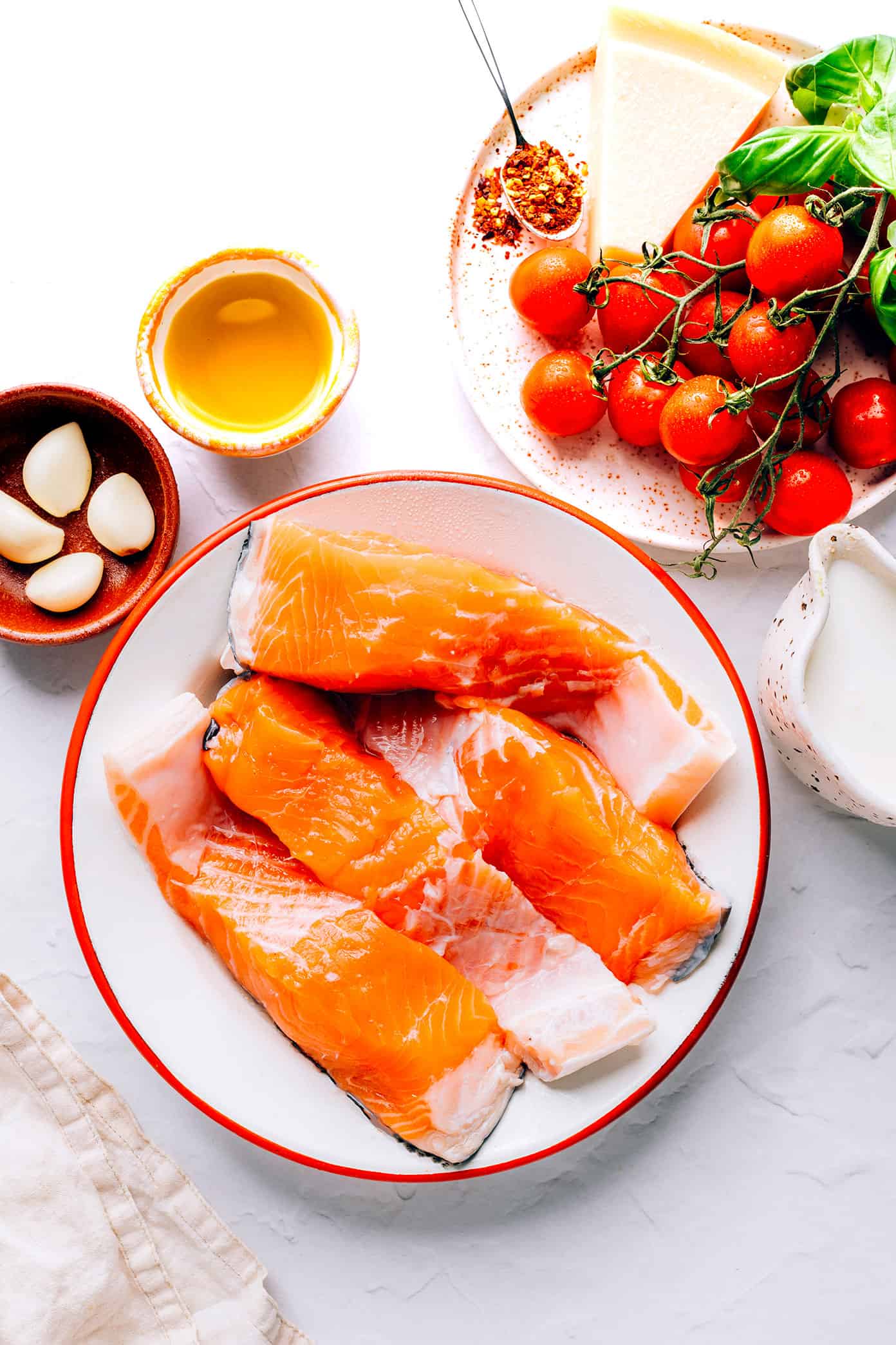 This Salmon in Burst Tomato Sauce is incredibly easy to make and simmered with the most delicious Italian-inspired garlicky cherry tomato basil cream sauce. Easy to make in 30 minutes, and delicious served for dinner with crusty bread, pasta, or rice and a simple side salad. | gimmesomeoven.com Salmon in Burst Tomato Sauce Ingredients