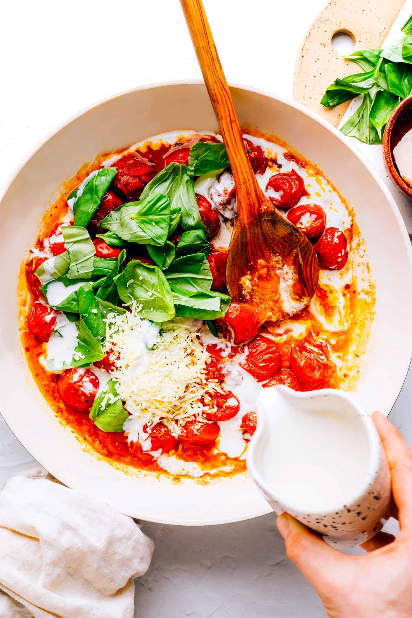 This Salmon in Burst Tomato Sauce is incredibly easy to make and simmered with the most delicious Italian-inspired garlicky cherry tomato basil cream sauce. Easy to make in 30 minutes, and delicious served for dinner with crusty bread, pasta, or rice and a simple side salad. | gimmesomeoven.com Adding cream to burst tomato sauce with basil