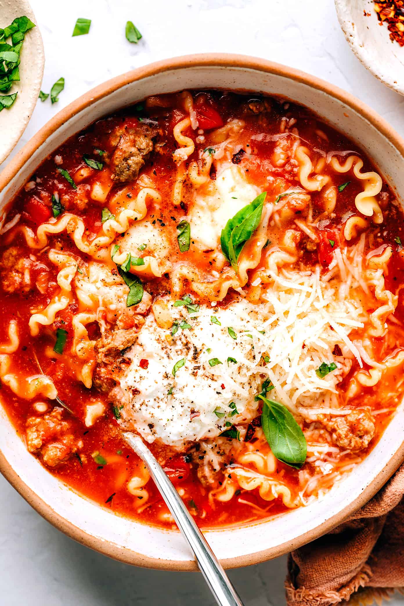 This easy lasagna soup recipe is made with Italian sausage (traditional or plant-based), a garlicky tomato herb broth, your choice of pasta, and three types of cheese (hello, mozzarella, ricotta AND Parmesan). Easy to make vegetarian, vegan and/or gluten-free if you'd like. And always such a cozy Italian 30-minute dinner recipe! | gimmesomeoven.com Lasagna Soup