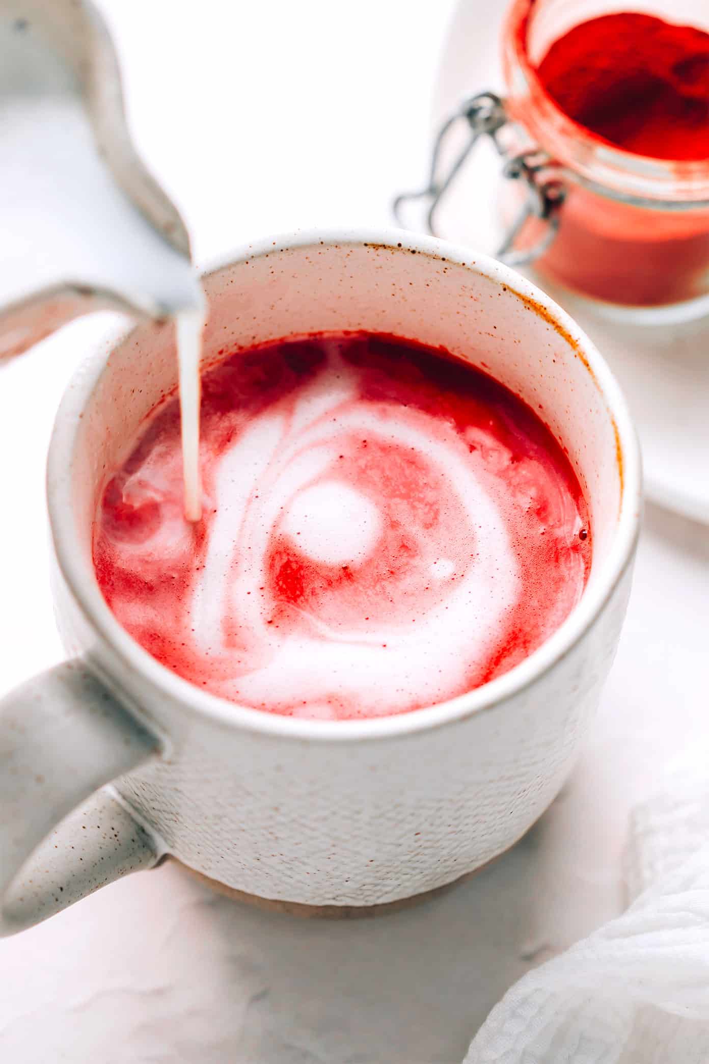 This nutrient-rich pink latte recipe is easy to make hot or iced and features a cozy mix of beetroot powder and warming spices (cardamom, cinnamon, ginger and cloves), your choice of milk and a hint of sweetener. Such cozy, vibrant and delicious drink! | gimmesomeoven.com Pink Beetroot Latte