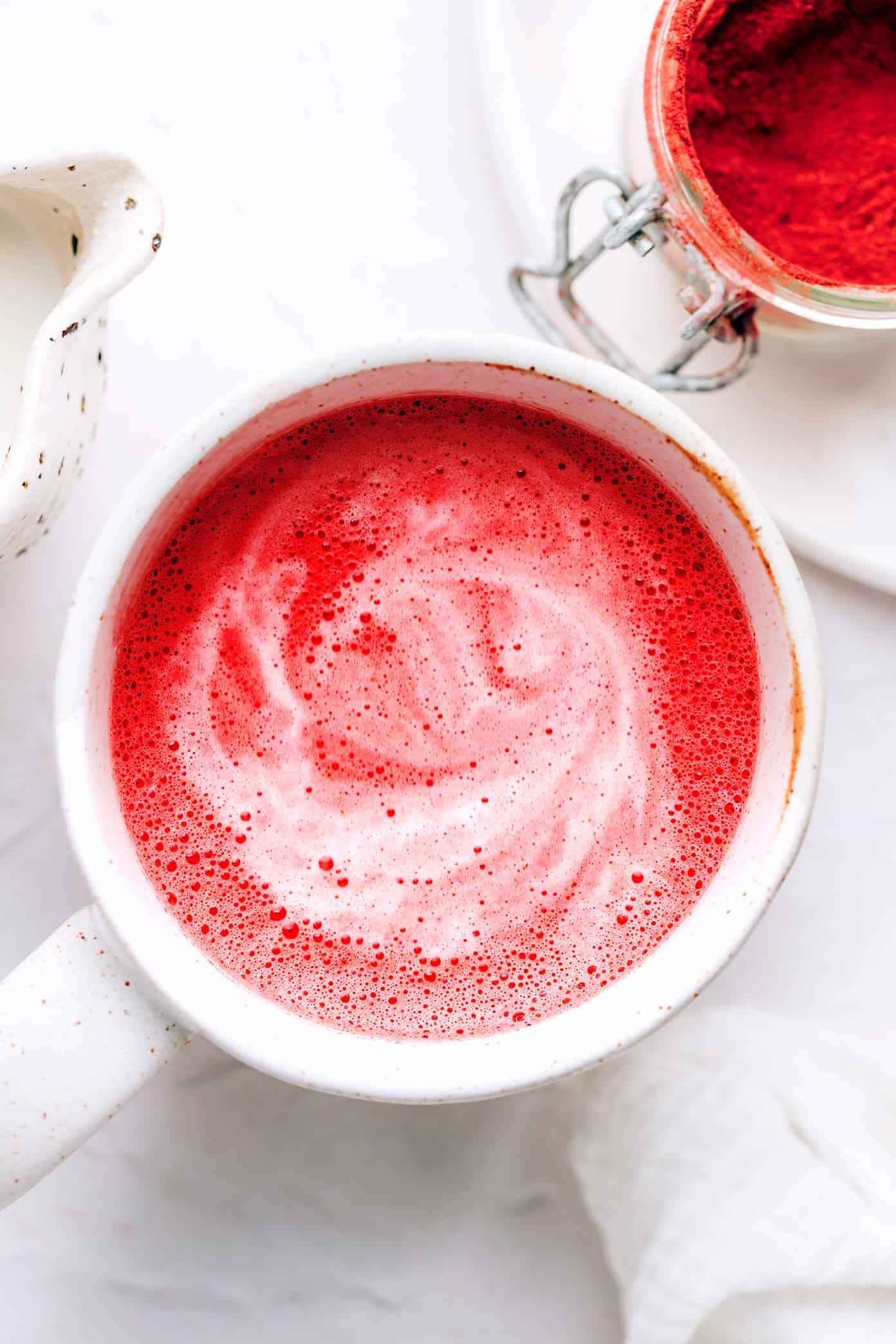 This nutrient-rich pink latte recipe is easy to make hot or iced and features a cozy mix of beetroot powder and warming spices (cardamom, cinnamon, ginger and cloves), your choice of milk and a hint of sweetener. Such cozy, vibrant and delicious drink! | gimmesomeoven.com Hot pink latte in mug