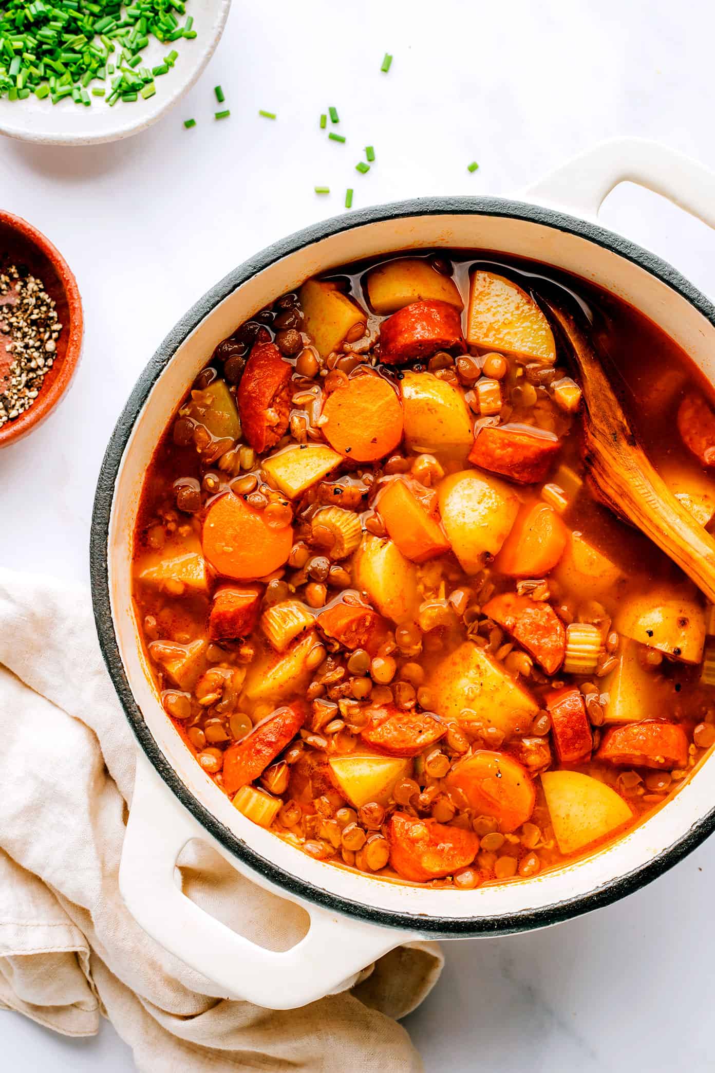 This Spanish Chorizo Lentil Stew recipe is incredibly easy to make, loaded up with veggies in a light paprika-tomato-garlic broth, and SO cozy and delicious. A great winter soup recipe for dinner when you're short on time! | gimmesomeoven.com Stockpot full of Spanish Chorizo Lentil Soup