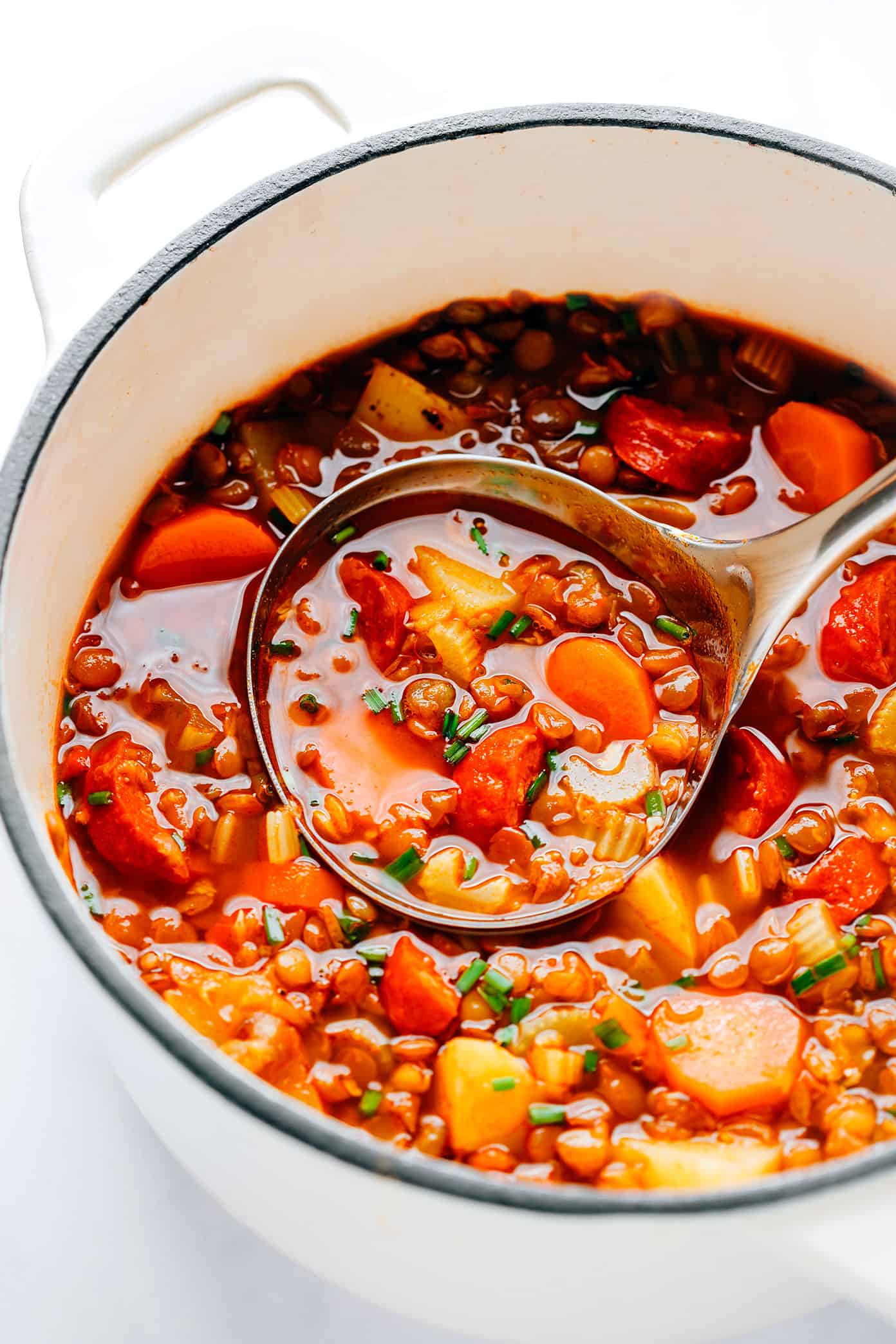This Spanish Chorizo Lentil Stew recipe is incredibly easy to make, loaded up with veggies in a light paprika-tomato-garlic broth, and SO cozy and delicious. A great winter soup recipe for dinner when you're short on time! | gimmesomeoven.com Spanish Chorizo Lentil Soup Pot with Ladle
