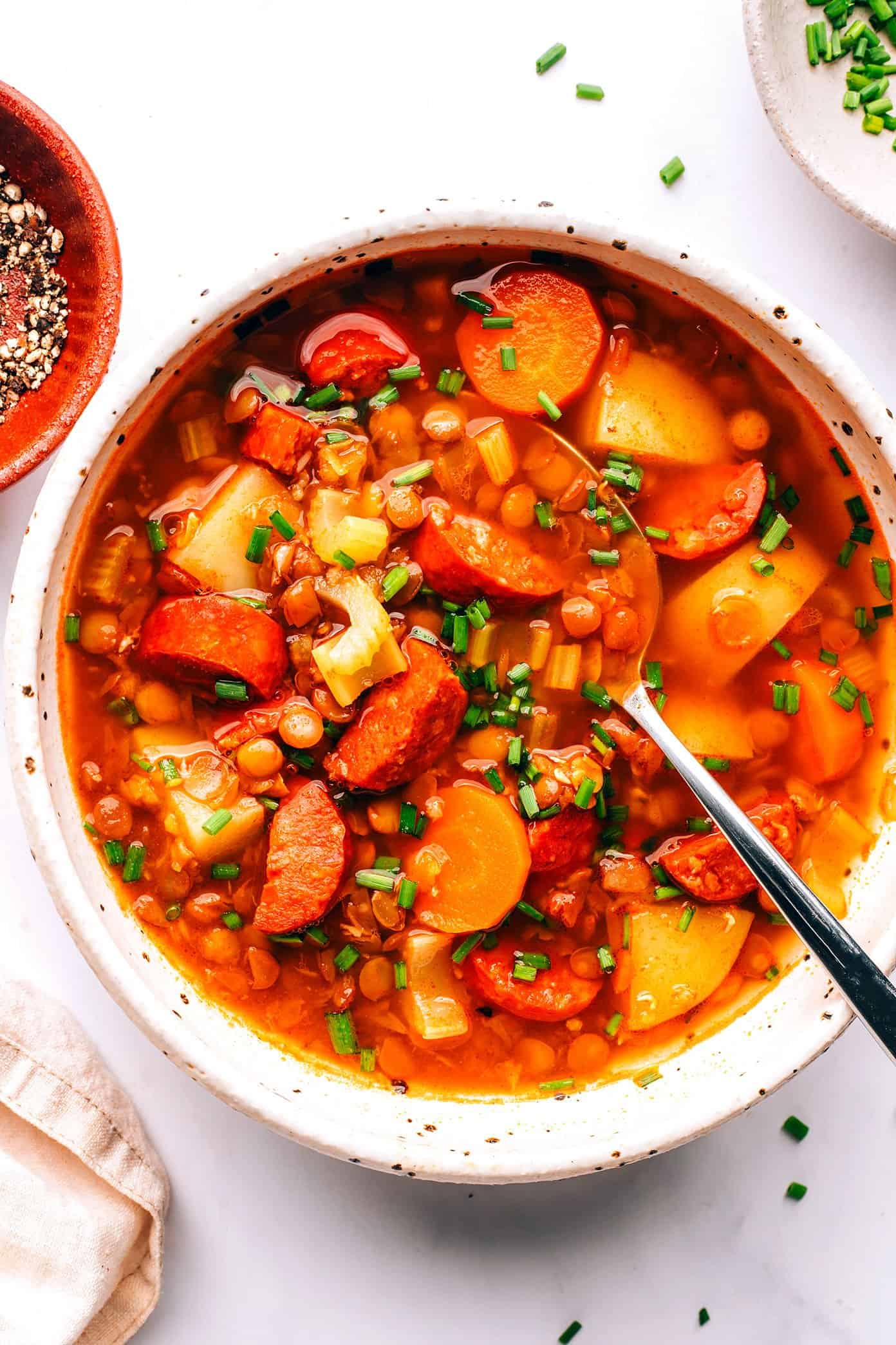 This Spanish Chorizo Lentil Stew recipe is incredibly easy to make, loaded up with veggies in a light paprika-tomato-garlic broth, and SO cozy and delicious. A great winter soup recipe for dinner when you're short on time! | gimmesomeoven.com Bowl of Spanish Chorizo Lentil Stew