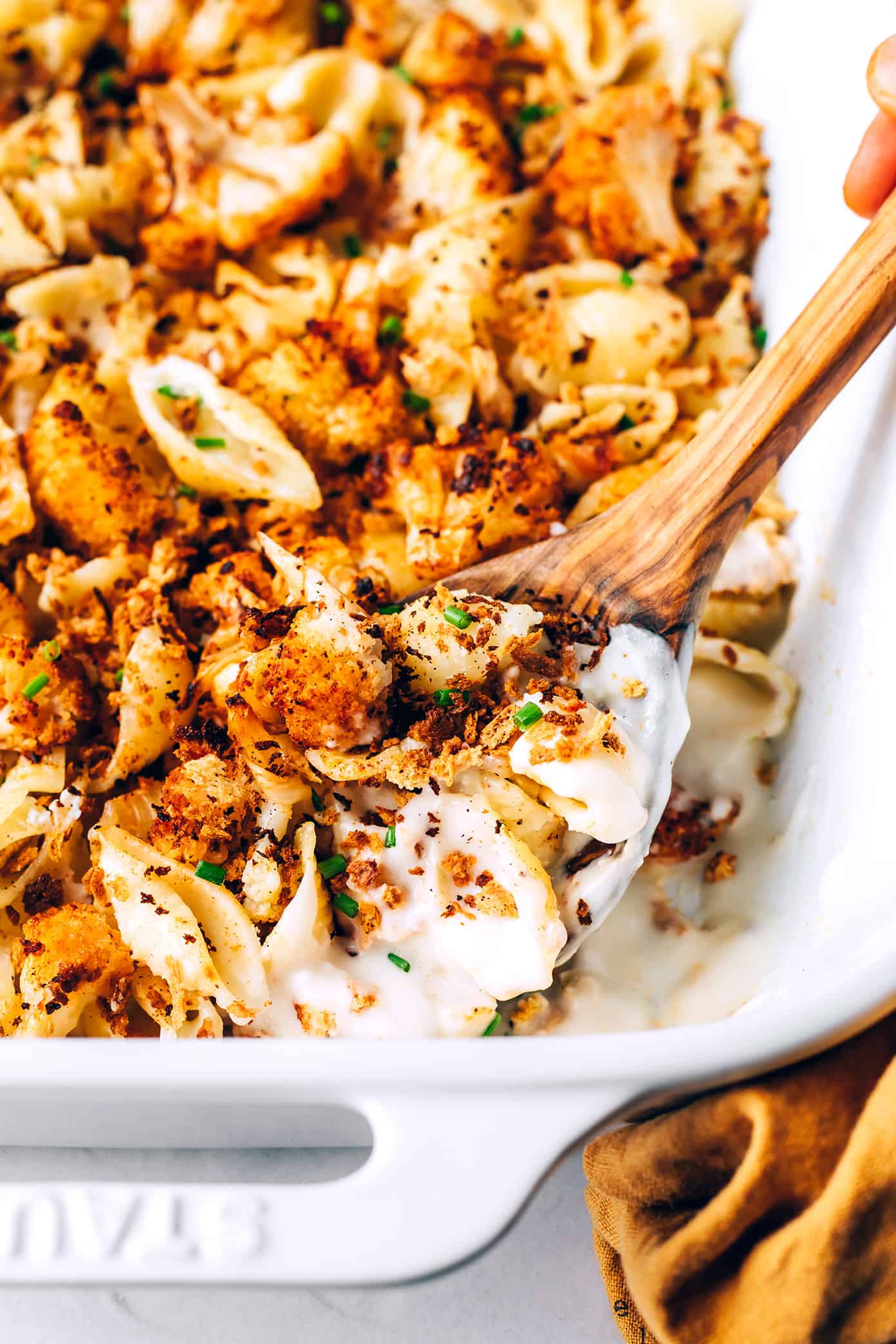 This Roasted Cauliflower Mac and Cheese features lots of zesty roasted cauliflower, a velvety cheddar cheese sauce, and sprinkling of toasted breadcrumbs. Easy to make and perfect when you're craving vegetarian comfort food for dinner. | gimmesomeoven.com Closeup of roasted cauliflower macaroni and cheese in pan