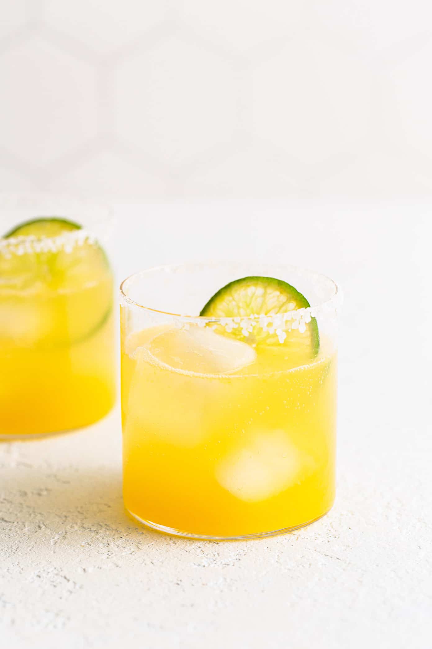 This virgin margarita mocktail recipe is quick and easy to make without alcohol, yet it's still so tangy, refreshing and delicious. Perfect to serve with your favorite Mexican food...or anytime you're craving a great mocktail! | gimmesomeoven.com Virgin Margaritas in Glasses with Lime