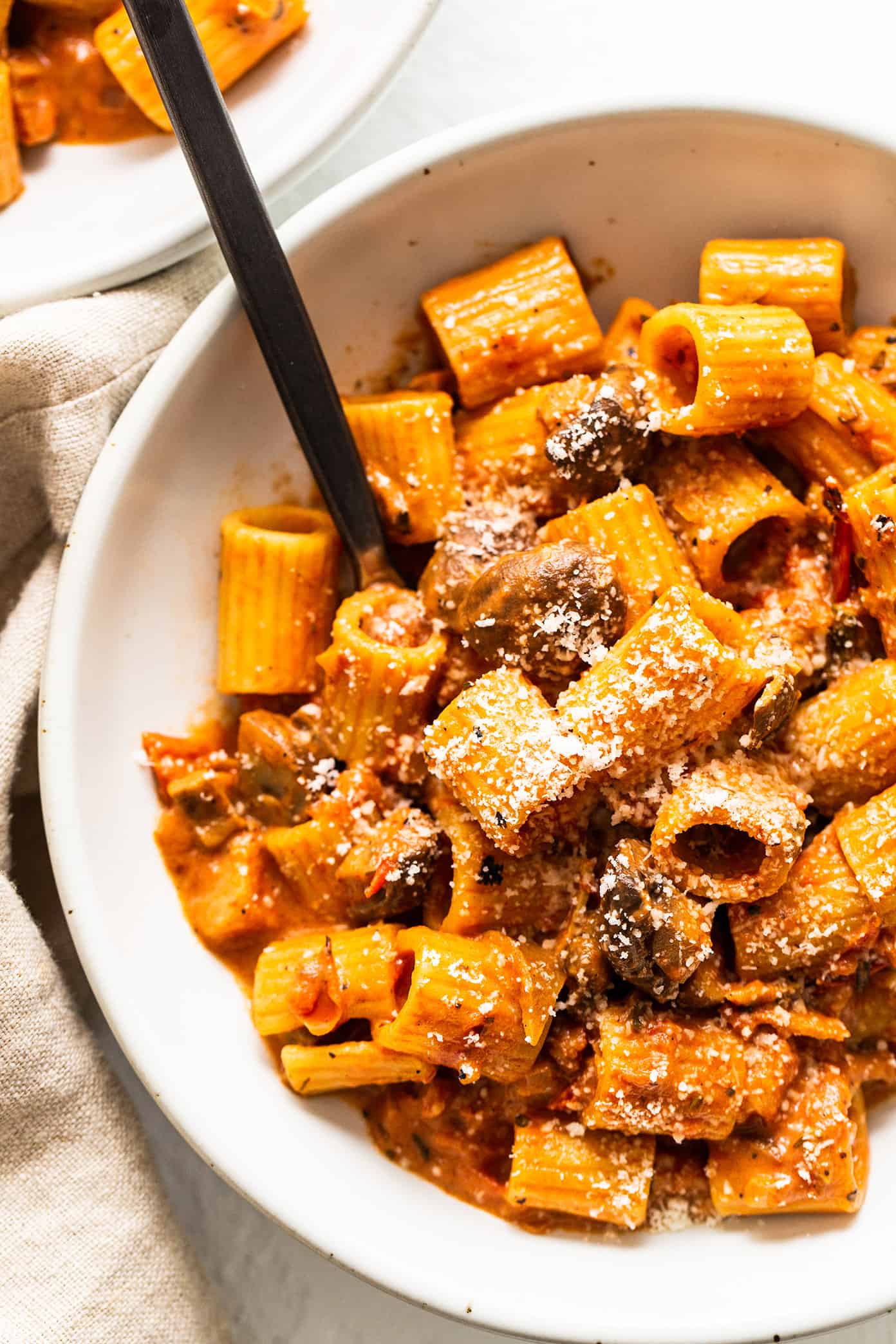Pasta alla Boscaiola ("woodsman-style pasta") features a rich blend of mushrooms and bacon tossed with pasta in a silky garlic herb tomato cream sauce. It's earthy, smoky, creamy, delicious and total Italian comfort food. | gimmesomeoven.com Pasta Boscaiola in Bowl with Parmesan