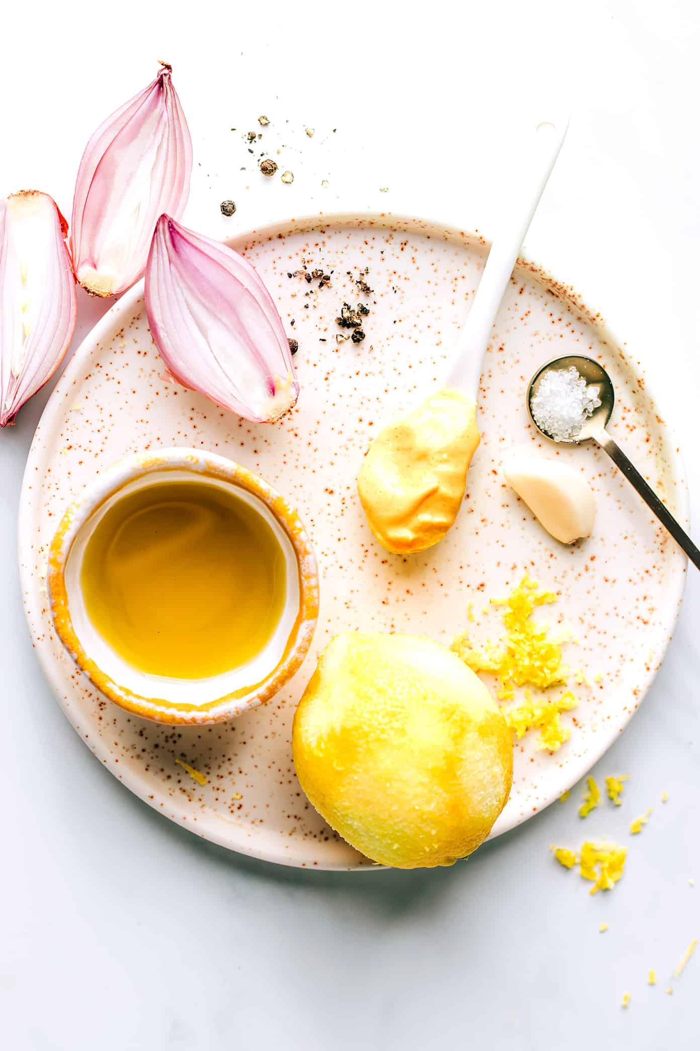 This delicious shallot vinaigrette (French vinaigrette) is quick and easy to make in 5 minutes with fresh lemon juice, garlic, Dijon, olive oil, salt and pepper. It's a versatile salad dressing that goes with just about everything, and always tastes so light and lovely. | gimmesomeoven.com Shallot (French) Vinaigrette Ingredients on a Plate