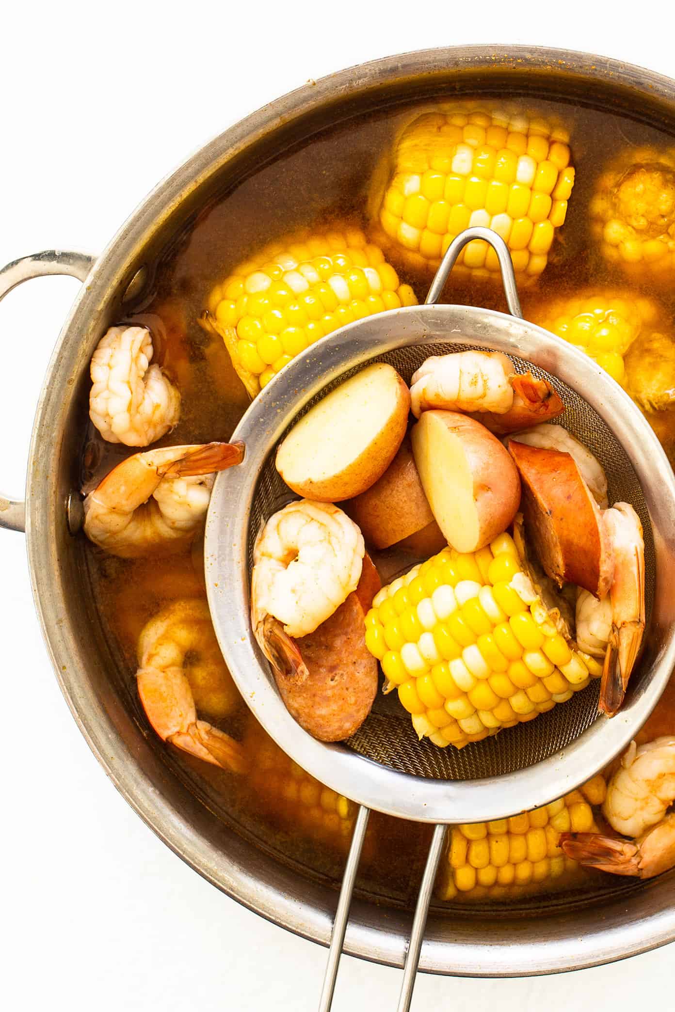 This classic shrimp boil recipe is super-easy to make with tender shrimp, sausage, potatoes, corn, zesty seasonings and a dreamy lemon garlic brown butter sauce. It's the perfect meal for easy entertaining and always a crowd fave! | gimmesomeoven.com Shrimp Boil in Stockpot