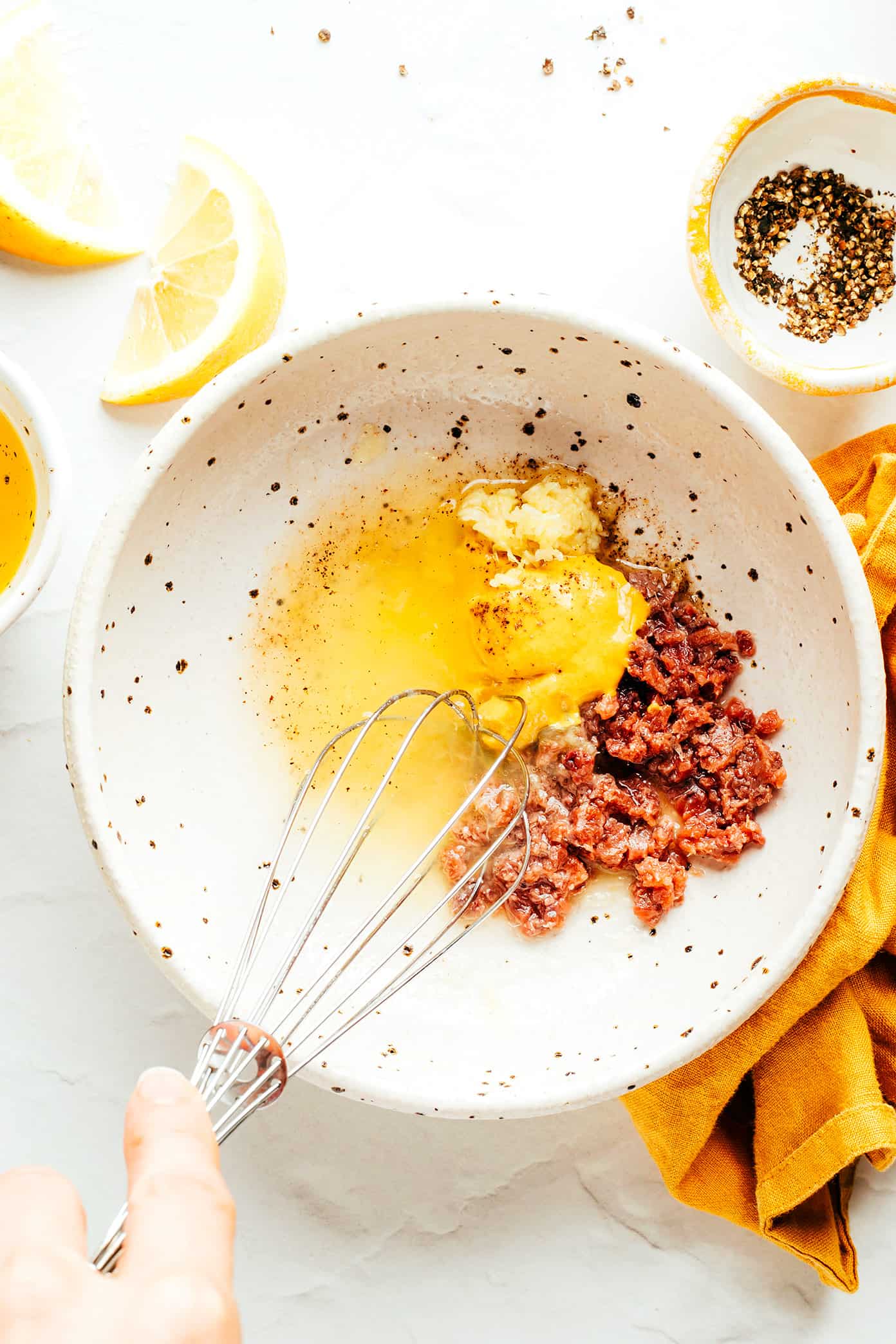 This "caesar-ish" dressing (anchovy vinaigrette) recipe is quick and easy to make with just 5 simple ingredients, and it's full of the most delicious, bold, savory, umami flavors. Perfect for tossing with salads, pasta, vegetables, seafood, meat, burgers, or whatever else sounds good! | gimmesomeoven.com Whisking anchovy vinaigrette