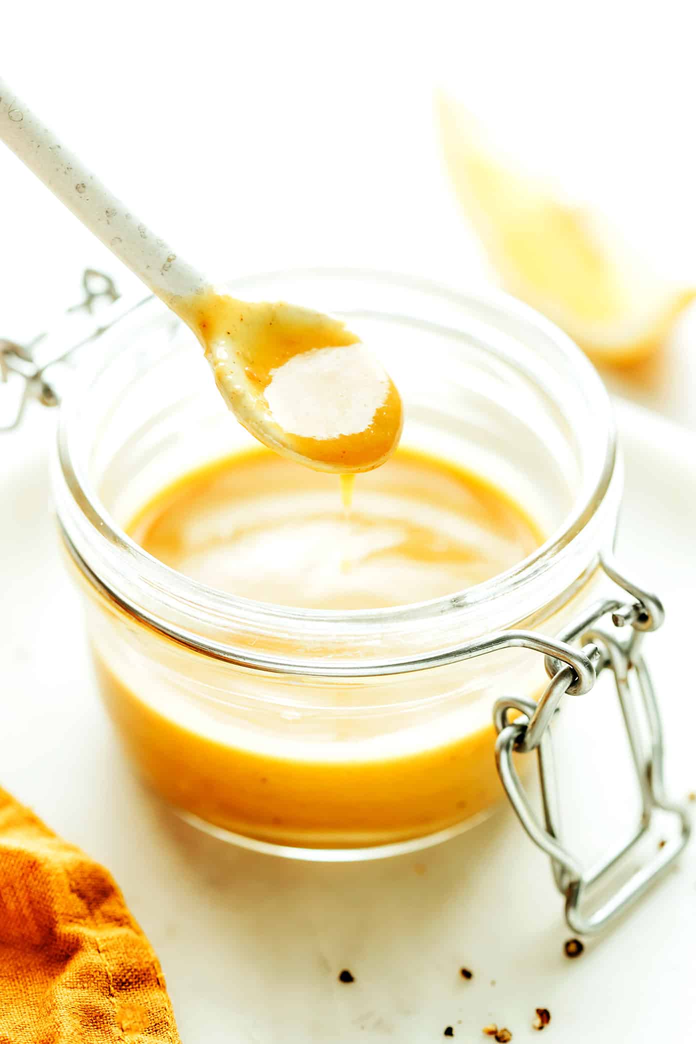 This "caesar-ish" dressing (anchovy vinaigrette) recipe is quick and easy to make with just 5 simple ingredients, and it's full of the most delicious, bold, savory, umami flavors. Perfect for tossing with salads, pasta, vegetables, seafood, meat, burgers, or whatever else sounds good! | gimmesomeoven.com Anchovy Vinaigrette in jar with spoon