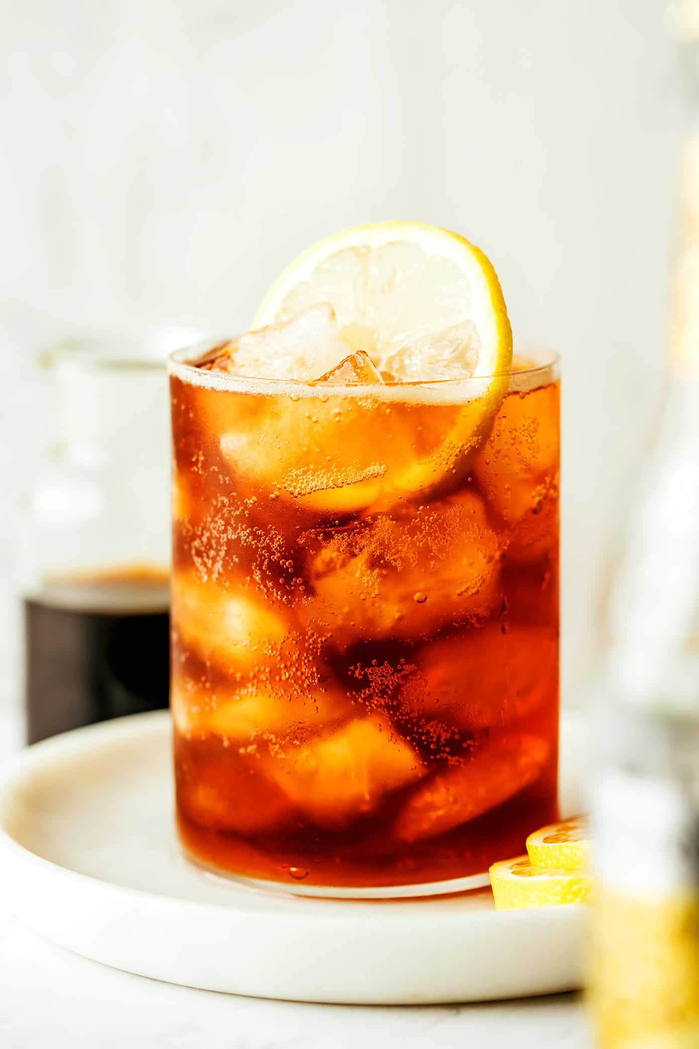 This cold brew tonic recipe is easy to make in a few minutes with three ingredients (cold brew coffee concentrate, tonic water, slice of lemon or orange, plus ice). Always such a refreshing, fizzy and delicious drink! | gimmesomeoven.com Cold Brew Tonic Drink in Glass with lemon