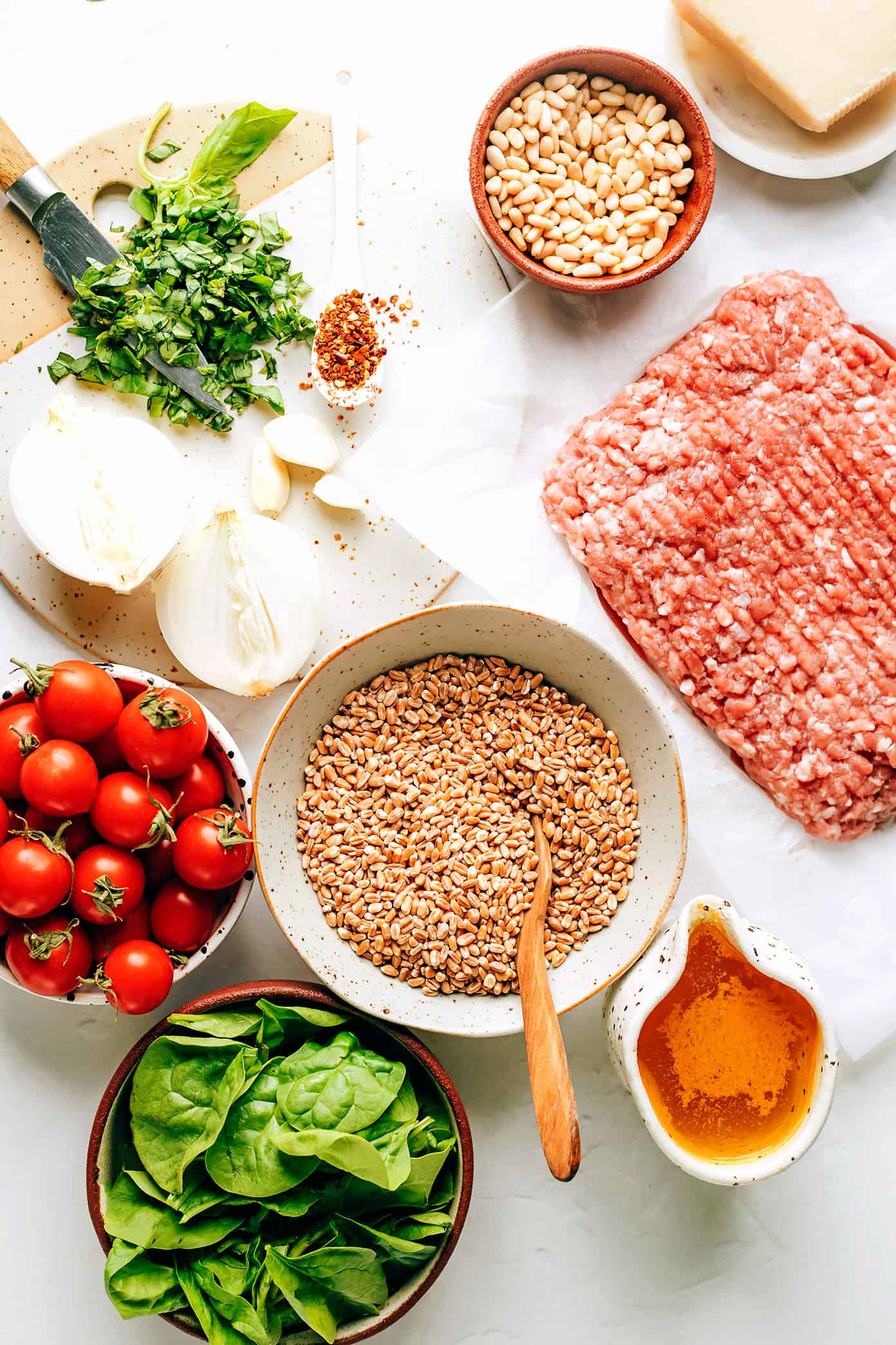 This one pot farro recipe is slow-simmered with Italian sausage, cherry tomatoes, fresh basil, garlic, spinach and finished with a sprinkling of pine nuts and Parmesan. Such an easy dinner recipe and always SO delicious. Feel free to use plant-based sausage to make it vegetarian too! | gimmesomeoven.com One Pot Farro Ingredients