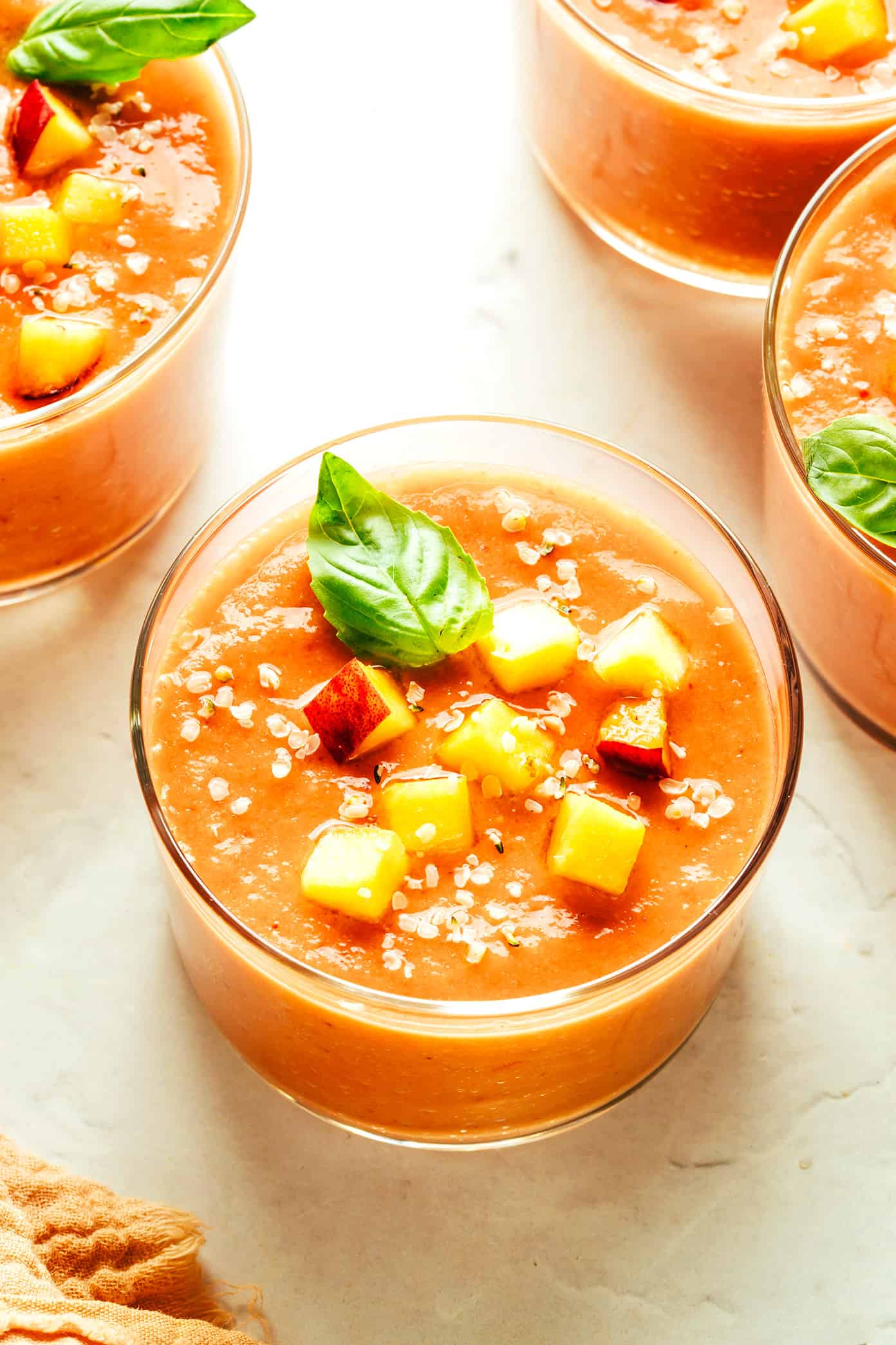 This fresh peach tomato gazpacho recipe features a delicious blend of sweet and savory flavors and comes together easily in just 10 minutes. It's the perfect cold soup for hot summer days, and always so delicious and refreshing! | gimmesomeoven.com Peach Gazpacho Soup with Basil