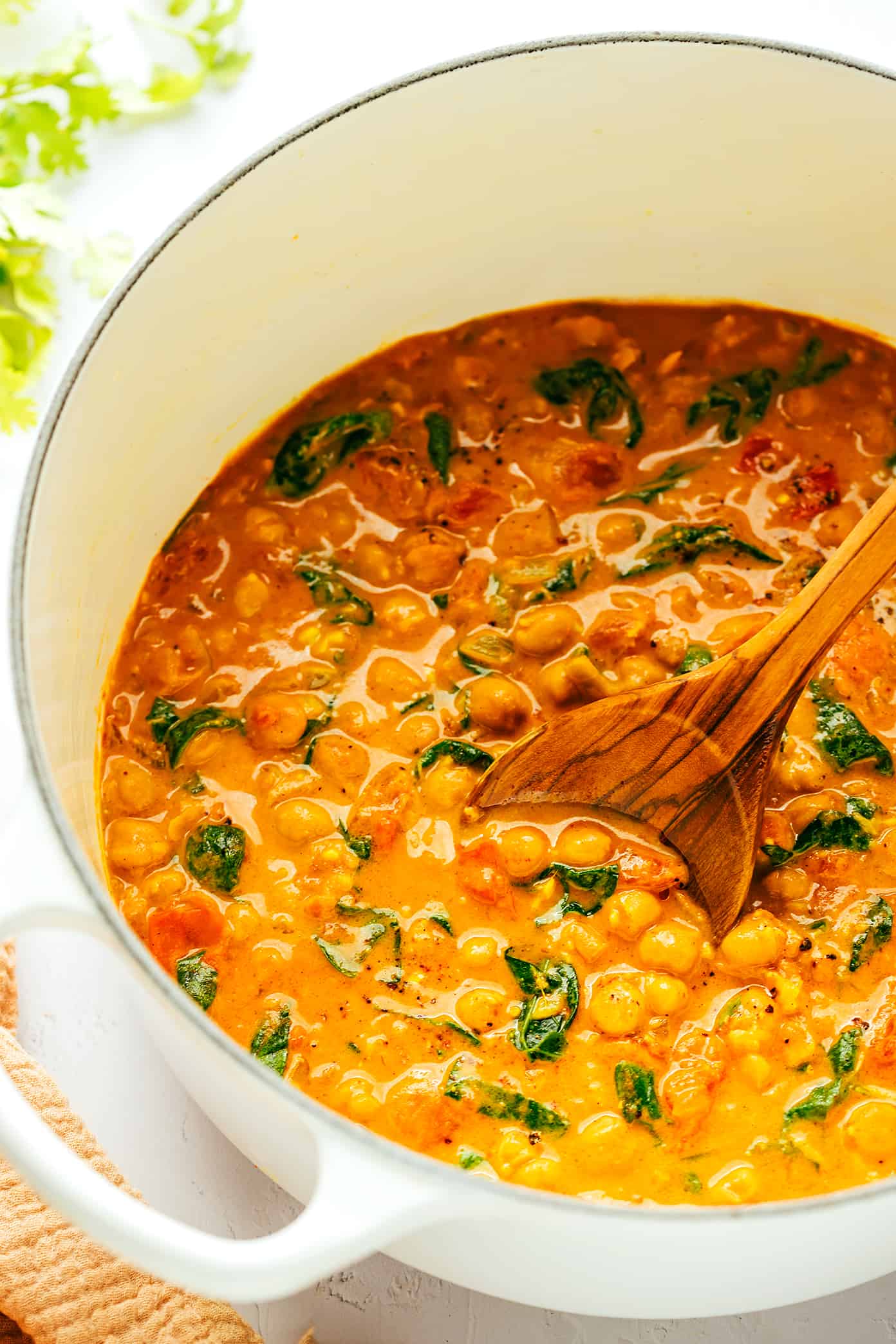 This Indian-inspired chickpea curry recipe is incredibly easy to make in less than 30 minutes and simmered in the most delicious lemon-ginger coconut curry sauce. Naturally gluten-free, vegetarian and vegan! | gimmesomeoven.com Easy Chickpea Curry in Pot with Wooden Spoon