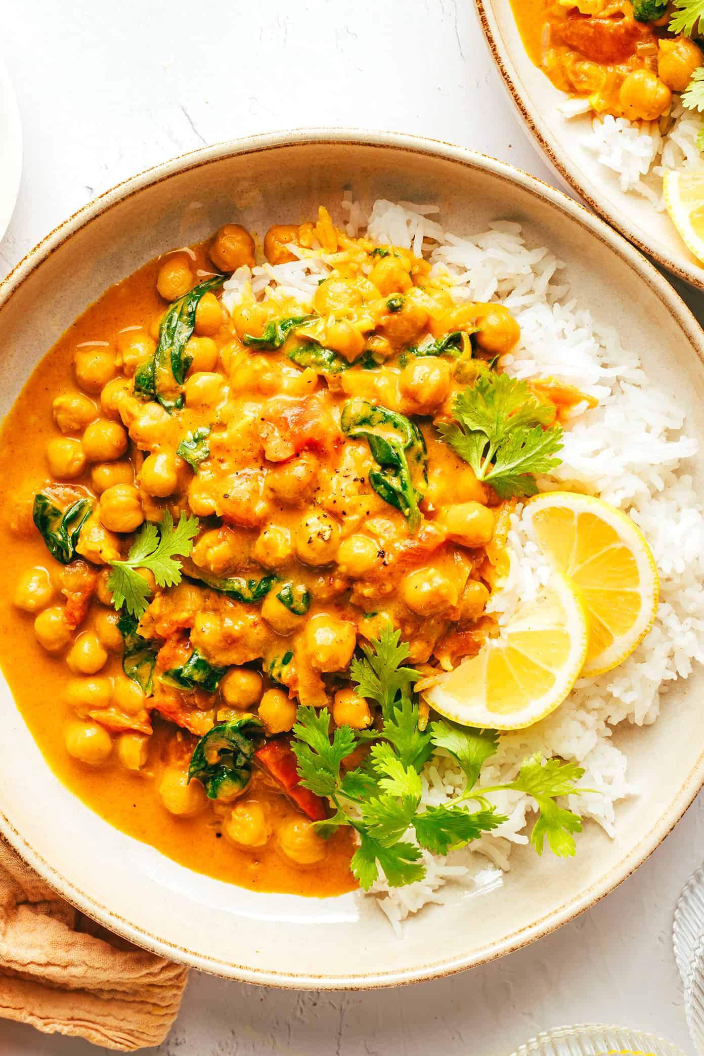 This Indian-inspired chickpea curry recipe is incredibly easy to make in less than 30 minutes and simmered in the most delicious lemon-ginger coconut curry sauce. Naturally gluten-free, vegetarian and vegan! | gimmesomeoven.com Easy Chickpea Curry with Rice and Lemons in Serving Bowls