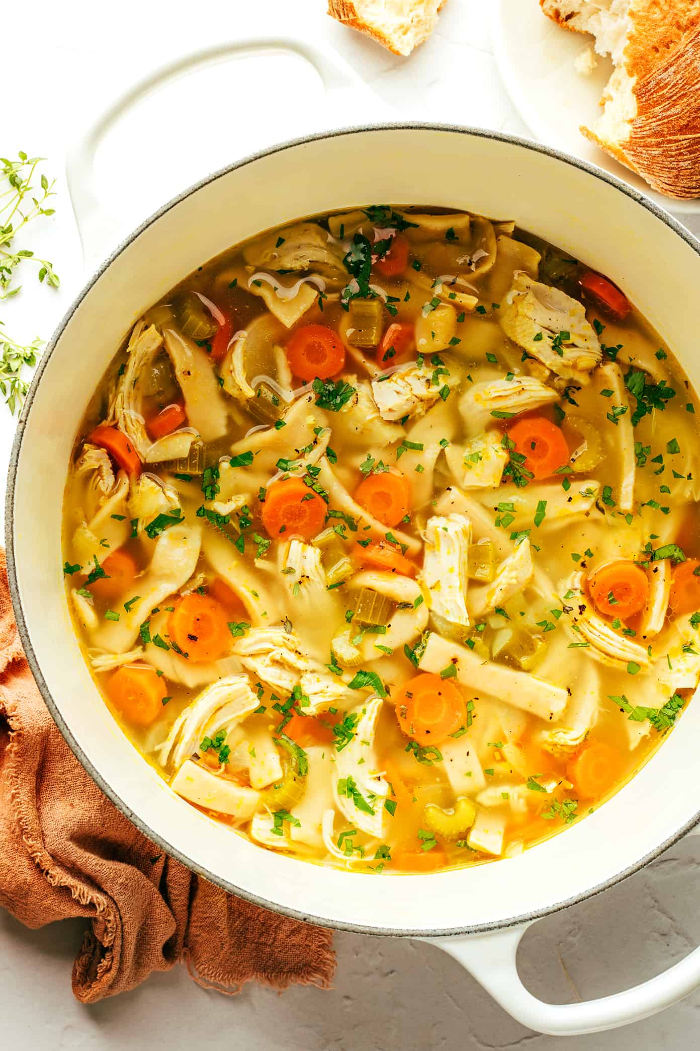 This homemade chicken noodle soup recipe is made with homestyle egg noodles, tender chicken, thick-cut veggies, and the coziest garlic-herb broth. The perfect comfort food to warm you right up! | gimmesomeoven.com Homestyle Chicken Noodle Soup in Pot with Parlsley